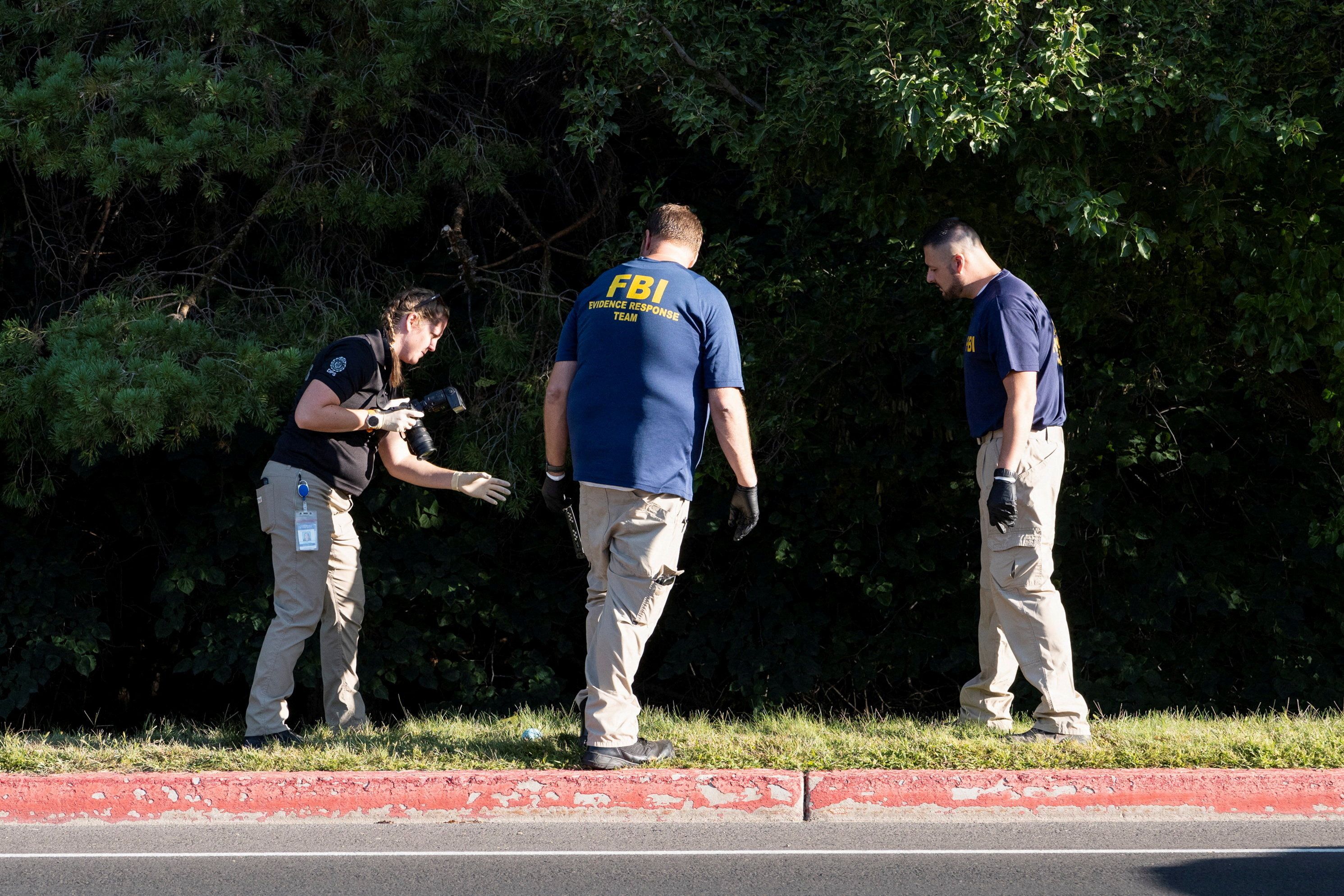 FBI agents search the woods near Utah Valley University along a possible escape route of the gunman who killed Charlie Kirk.