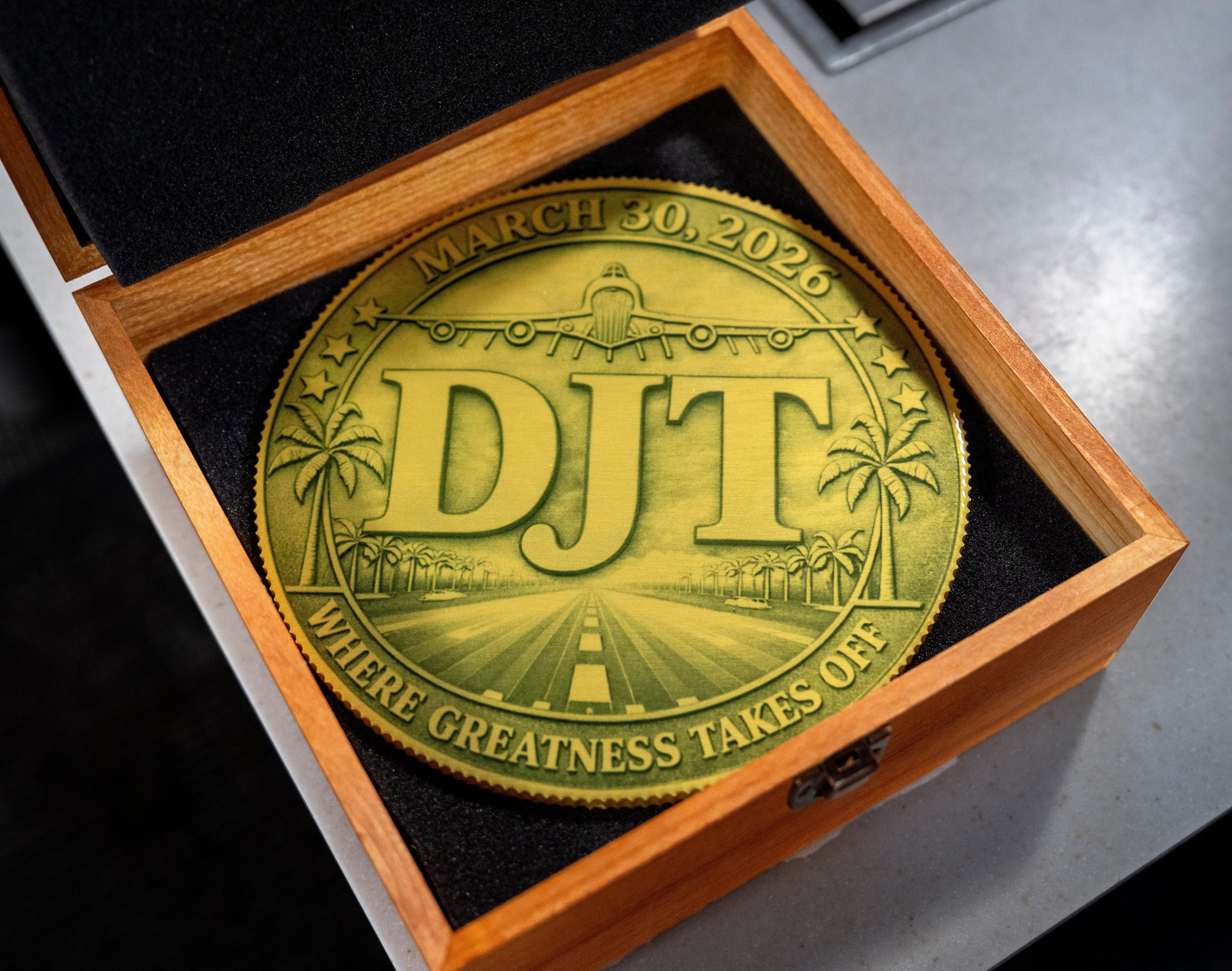 A golden coin honor President Trump for the new PBI name.