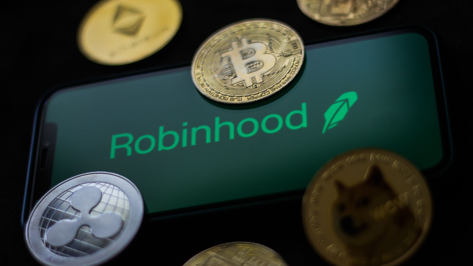 A digital screen that reads "Robinhood" surrounded by coins with different insignia 