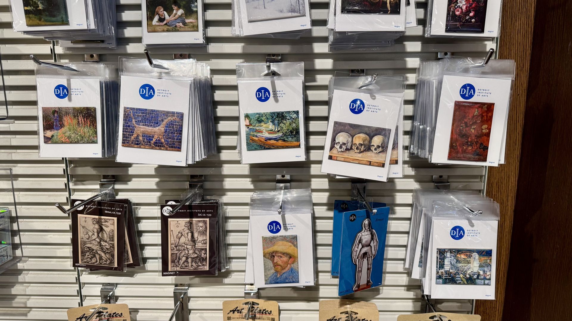 Display of Detroit Institute of Arts magnets featuring various artworks, including landscapes, skulls, a knight, and portraits.