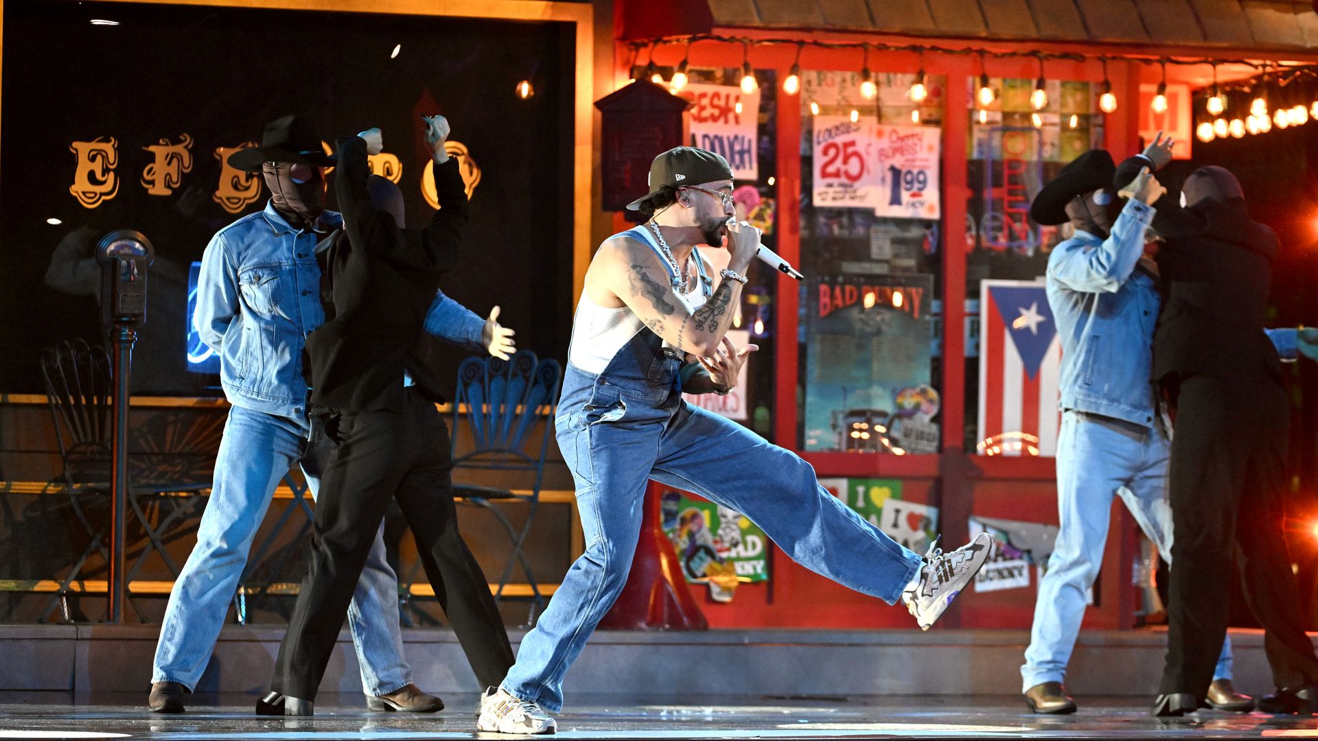 A man performing on a stage with other people.