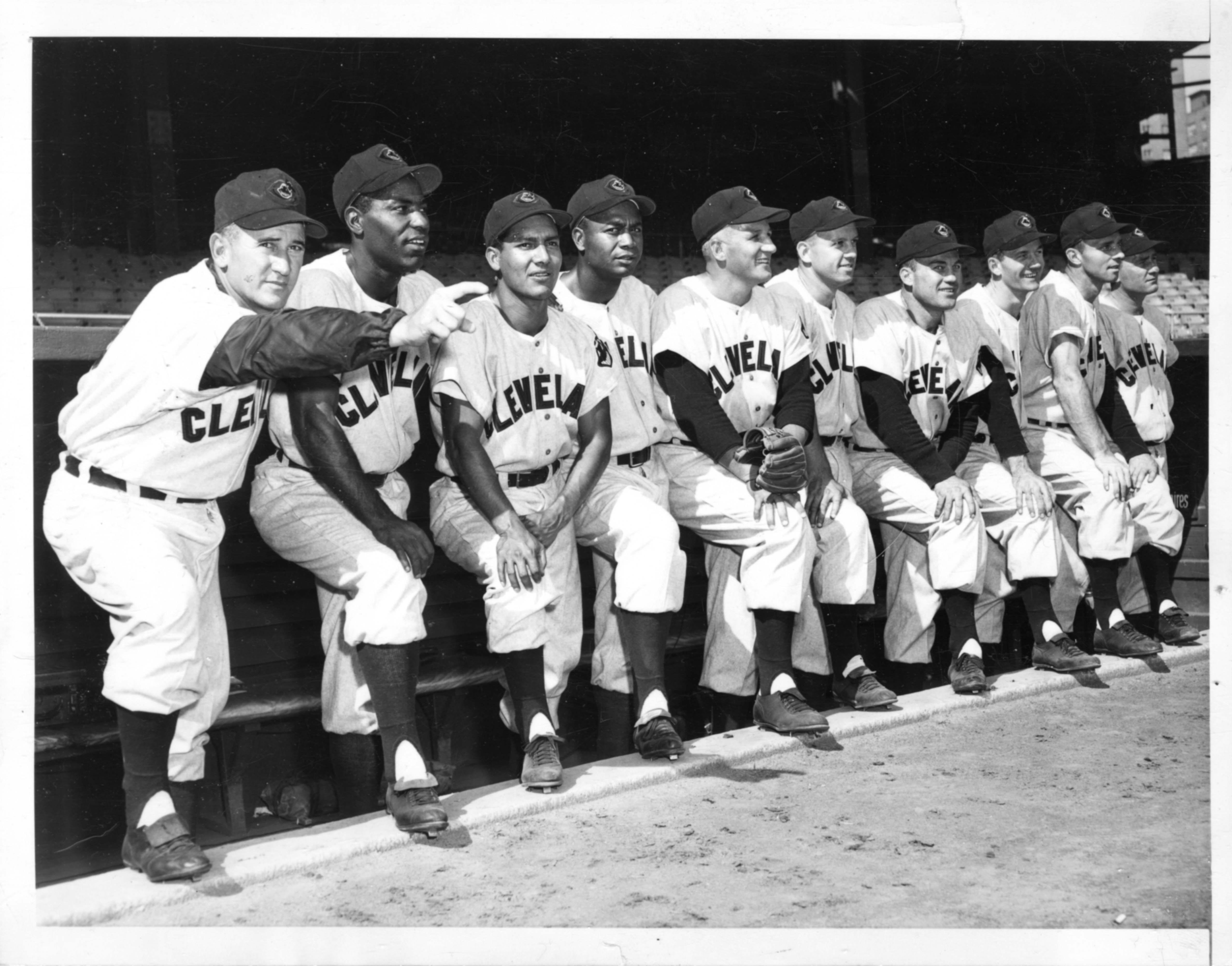 Members of the 1954 Cleveland Indians stand together just outside their dugout.