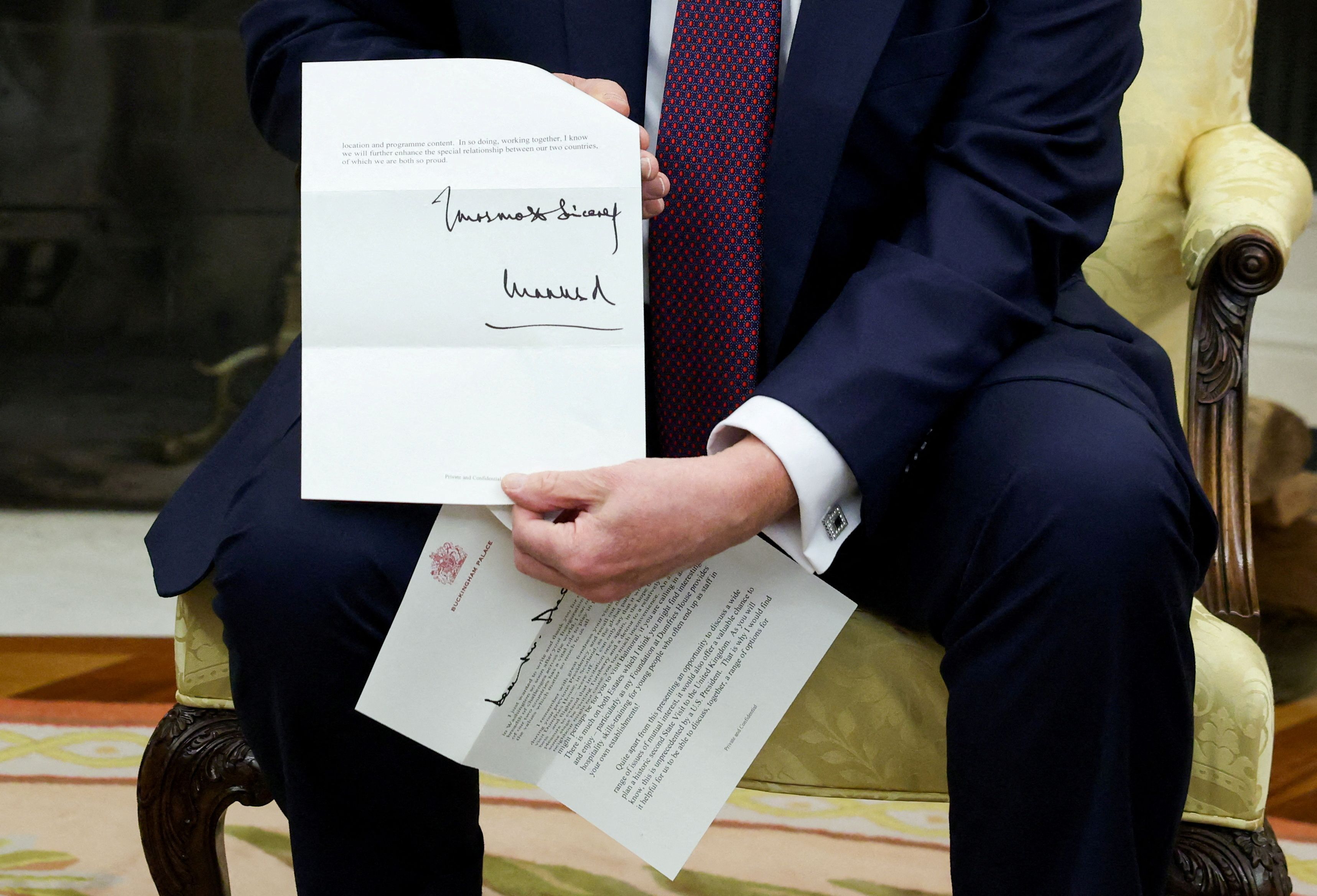 President Trump holds up a letter from King Charles III — given to him by Prime Minister Keir Starmer yesterday — inviting him to a state dinner.