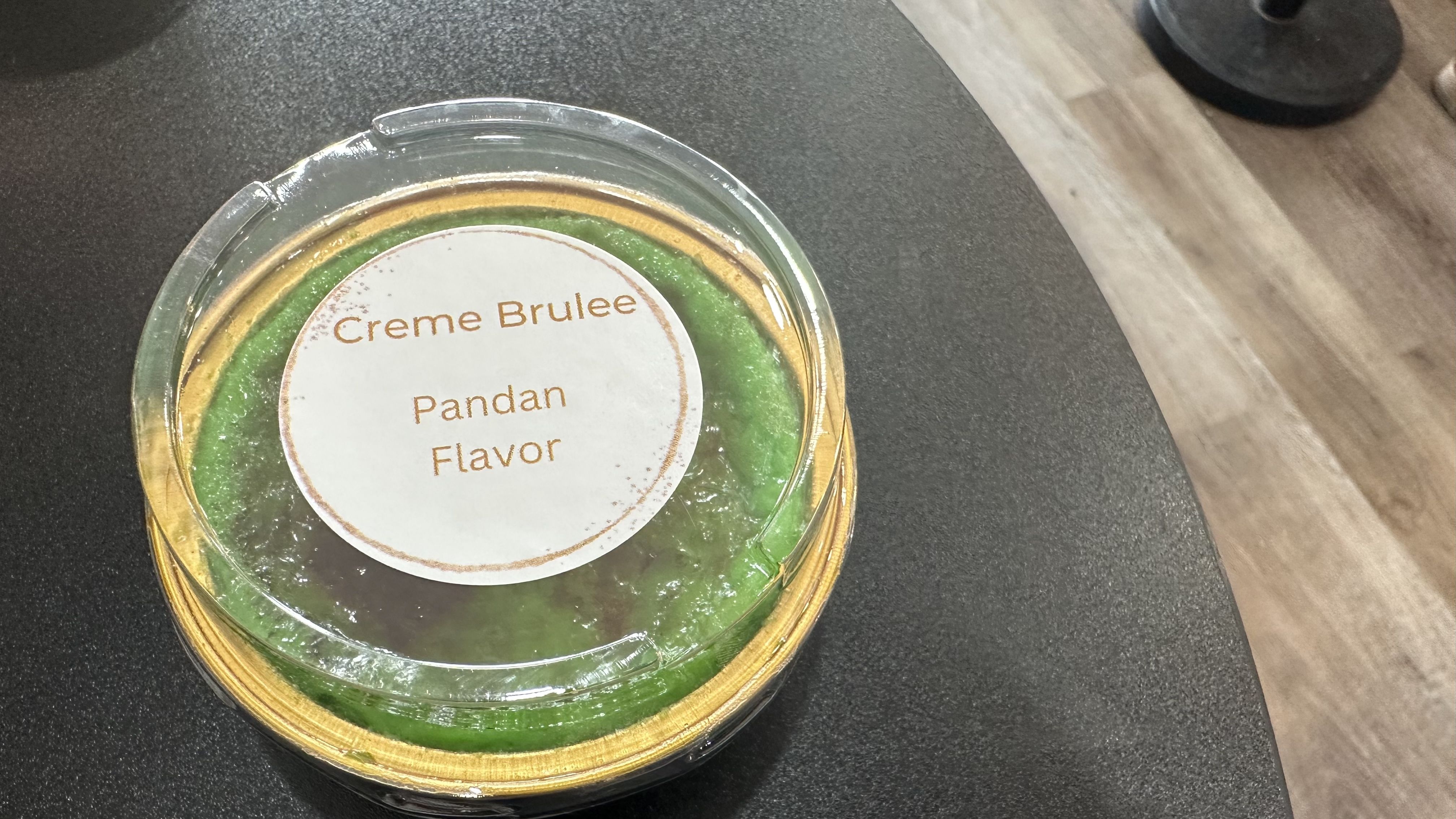 Photo shows a container of pandan creme brulee.