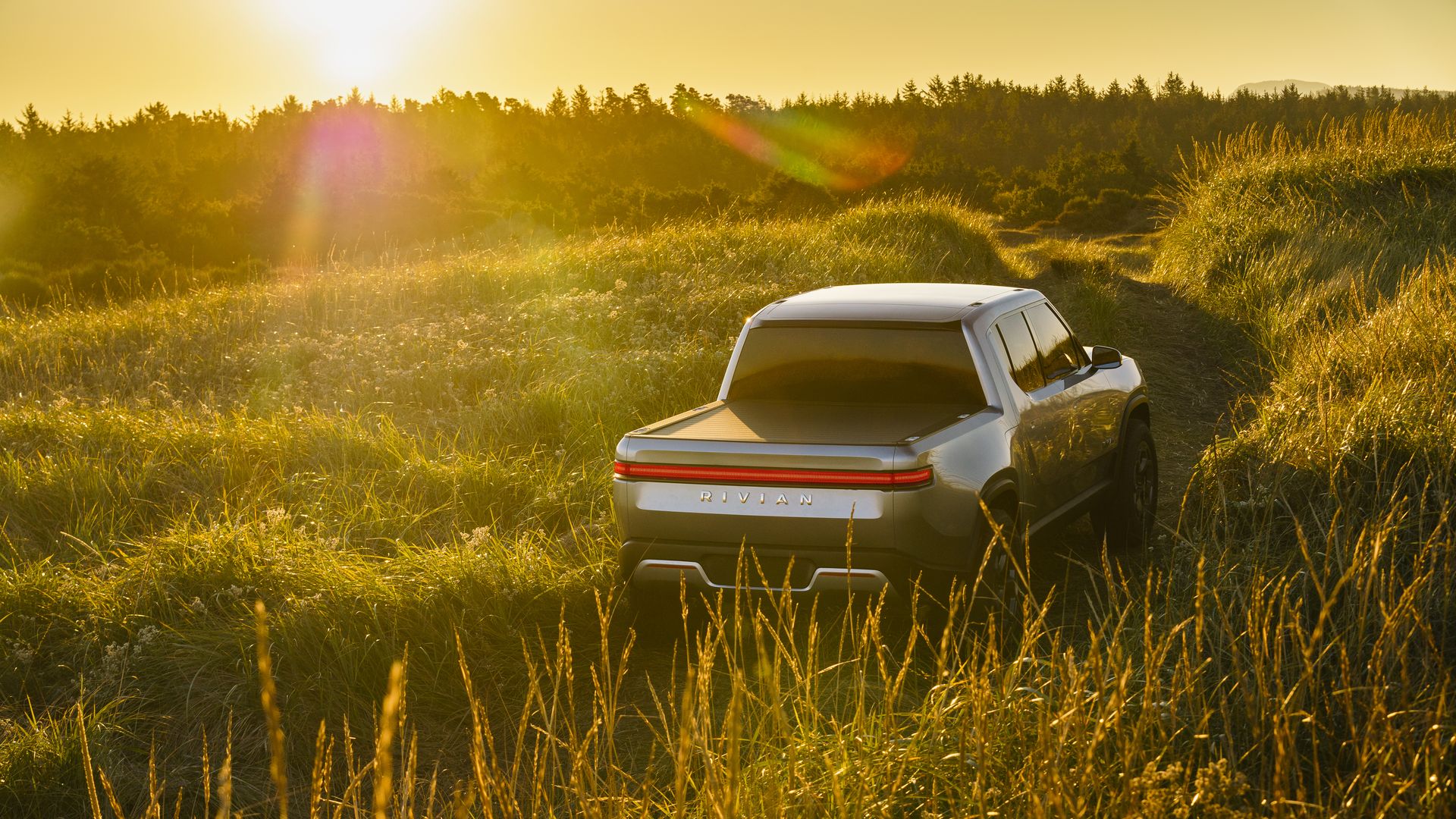 Image of Rivian R1T electric pickup truck in a field of grass