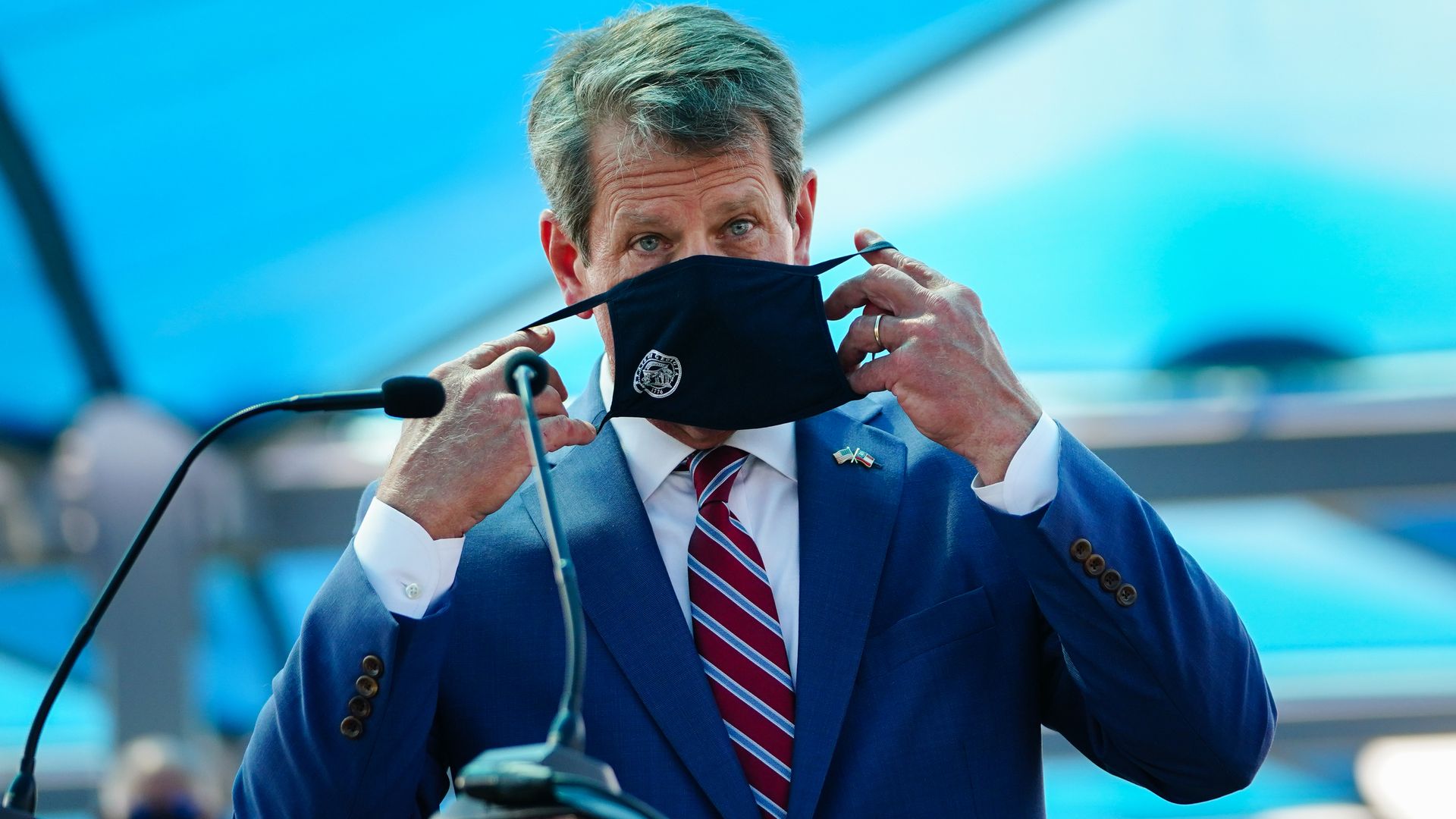 Brian Kemp puts a mask over his face