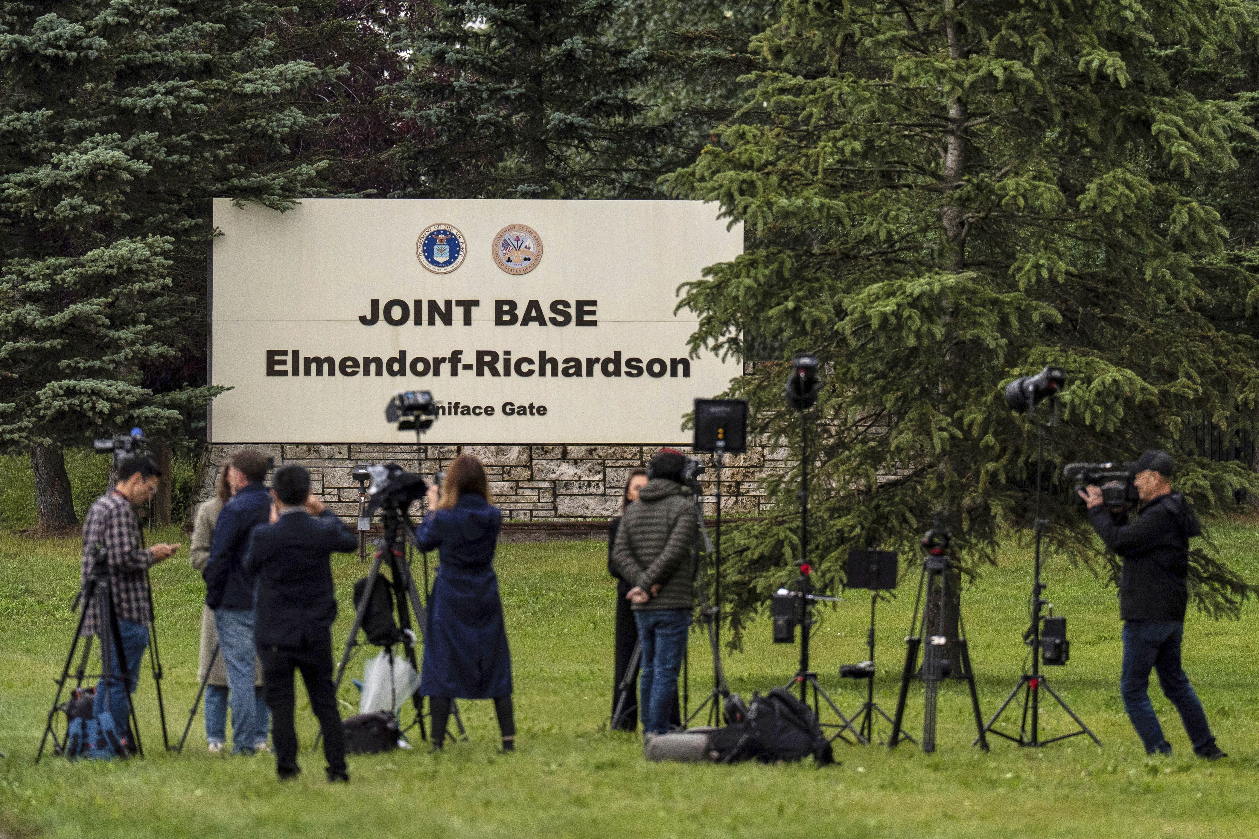 Members of the media stand outside Joint Base Elmendorf-Richardson in Anchorage, where the Trump-Putin summit will take place today.