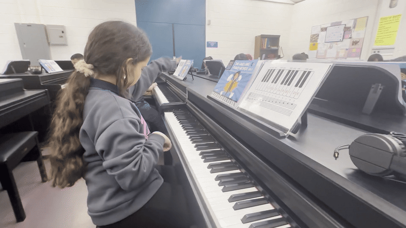 Maria Isabella Gil Villa, a third grader at Mario Umana Academy in East Boston, hits the D note from the low end of the piano and lifts her index finger to keep hitting D notes several octaves up. 