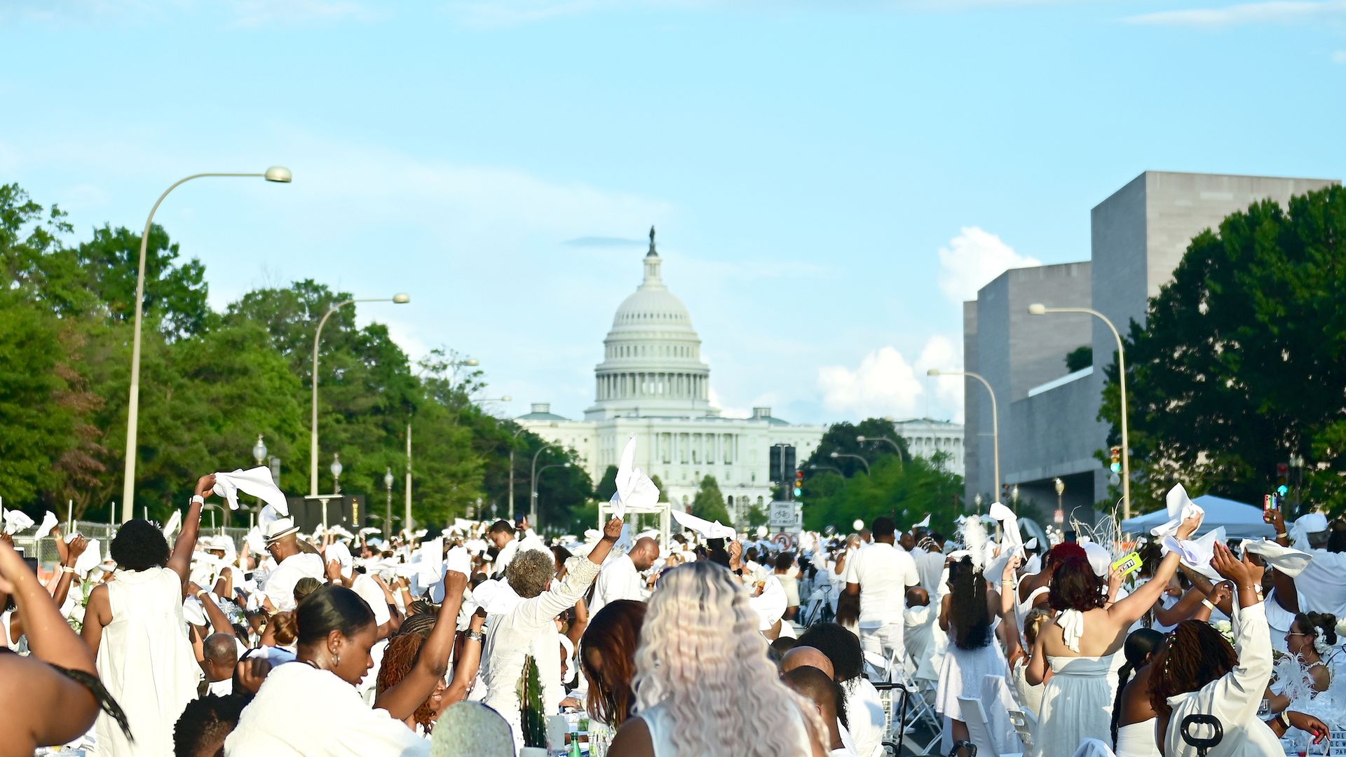 Attendees at Diner en Blanc in 2021 in front of the US Capitol wave white napkins, per custom. 