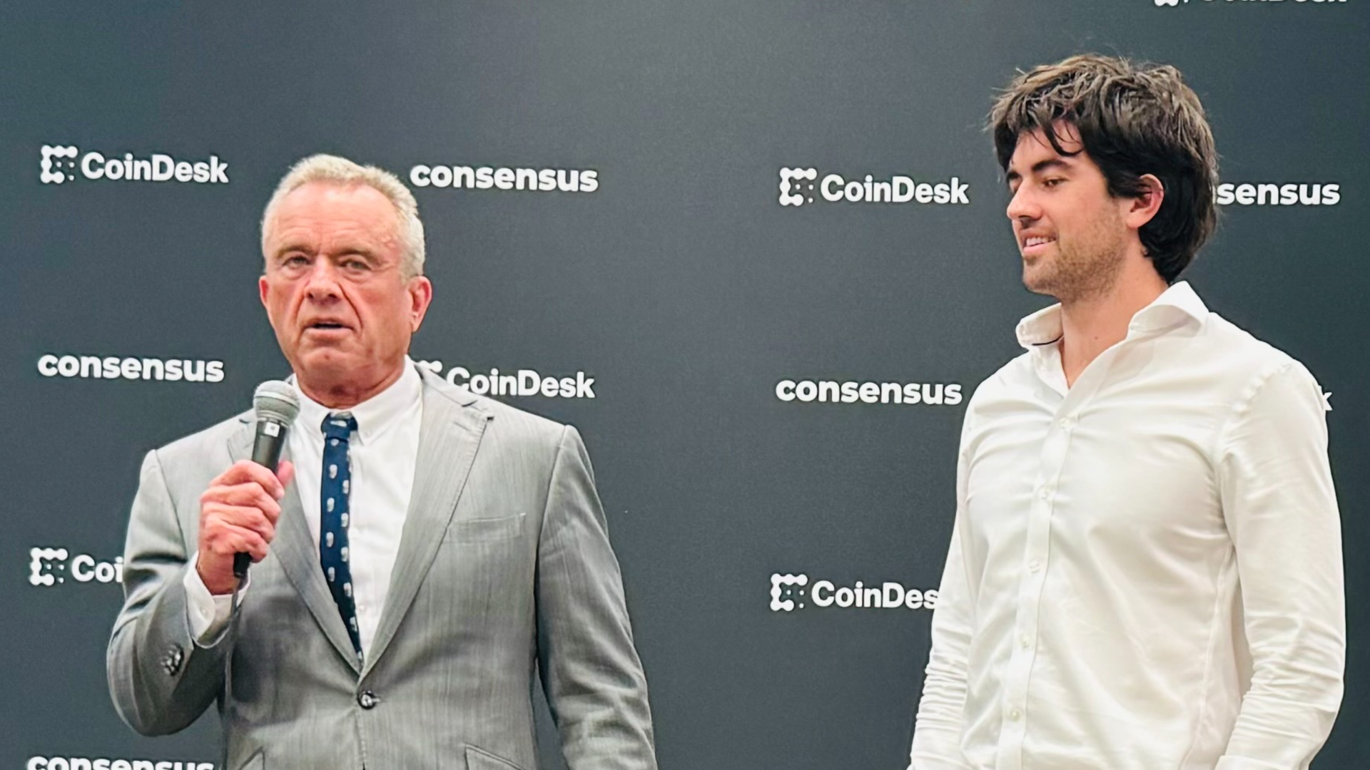 RFK Jr. standing next to one of his sons to answer questions from reporters during a media briefing at Consensus 2024.