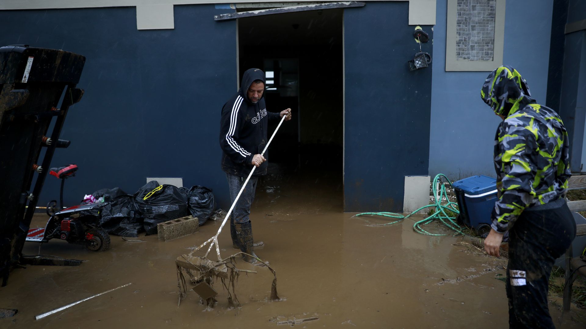 A man in a hoodie cleans floodwater in Puerto Rico 