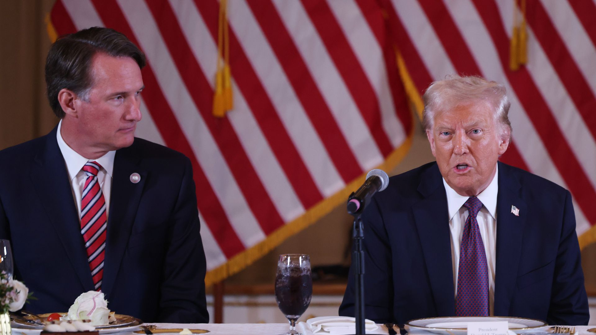 Donald Trump (R) speaks during a meeting as Virginia Governor Glenn Youngkin (L) looks on along with Republican governors at the Mar-a-Lago Club on January 09