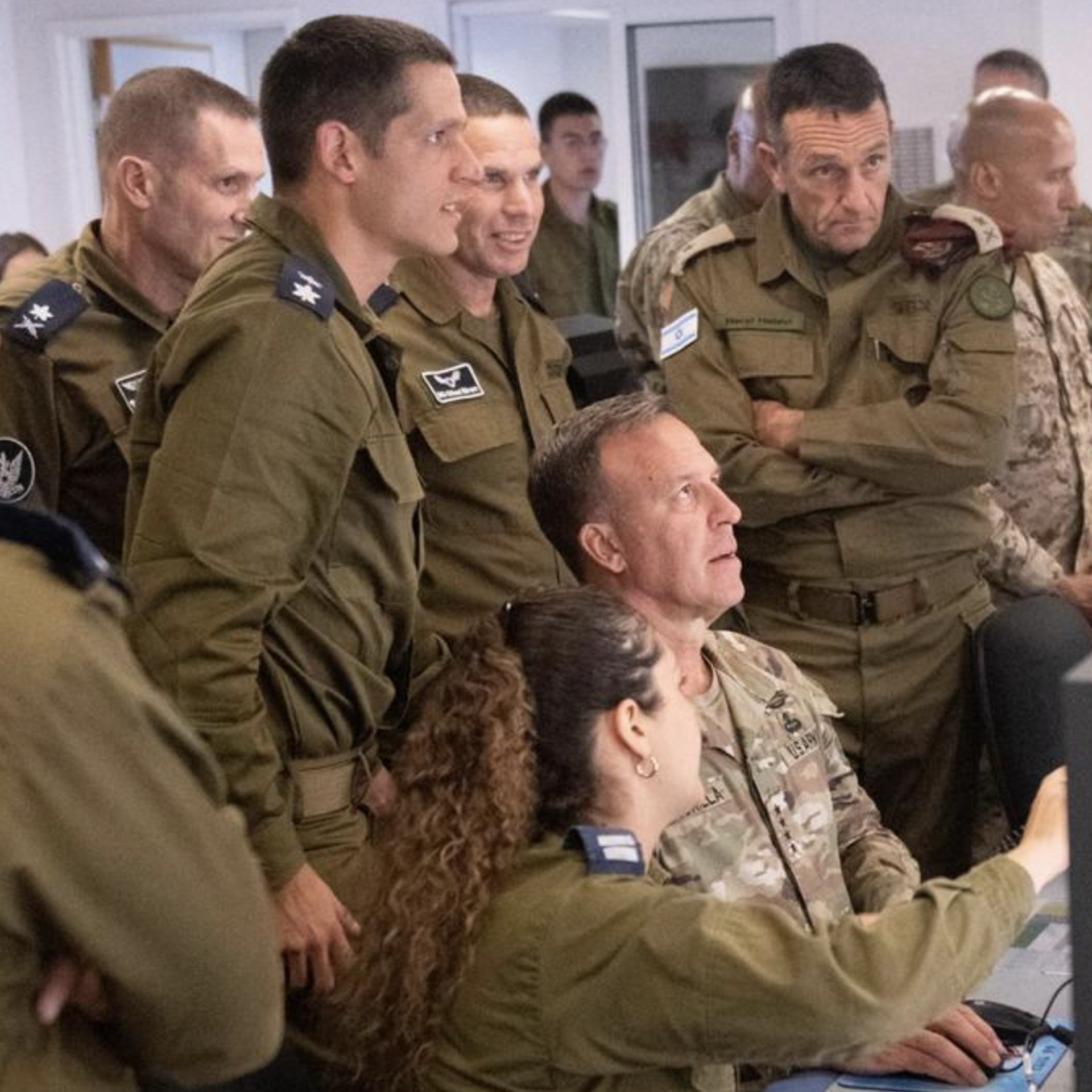 U.S. Gen. Michael Kurilla surrounded by Israeli soldiers in front of a computer.