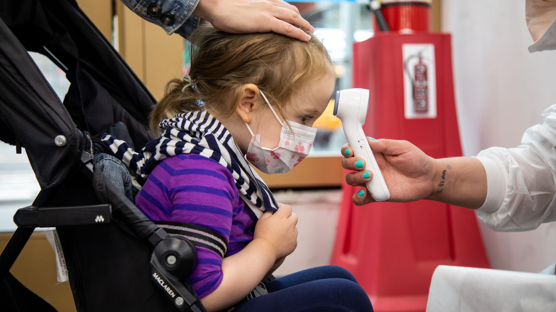 A girl has her temperature measured at a COVID-19 vaccination site in Times Square, New York, the United States, on June 22, 2022.
