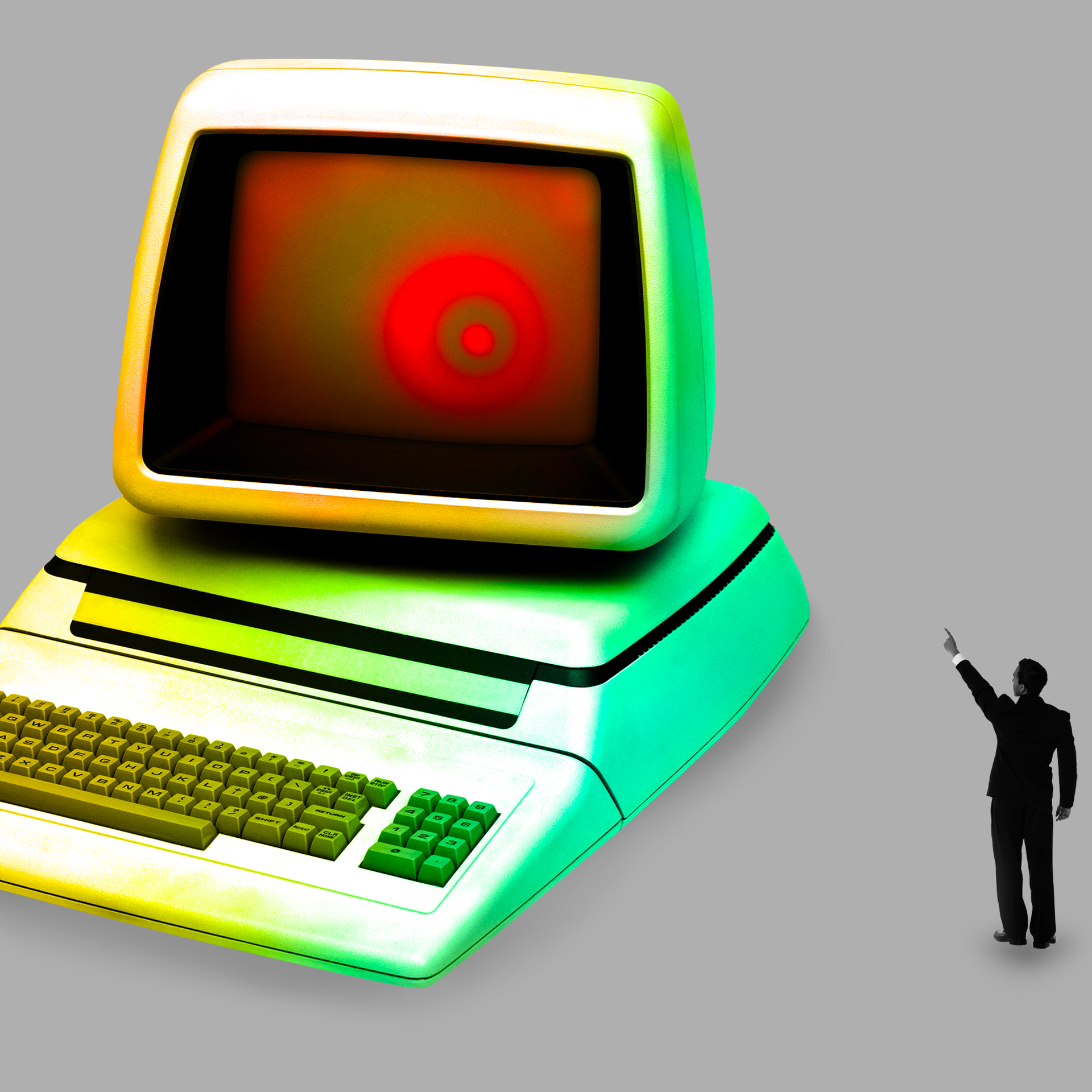 man in a suit pointing at a computer whose monitor is glowing red