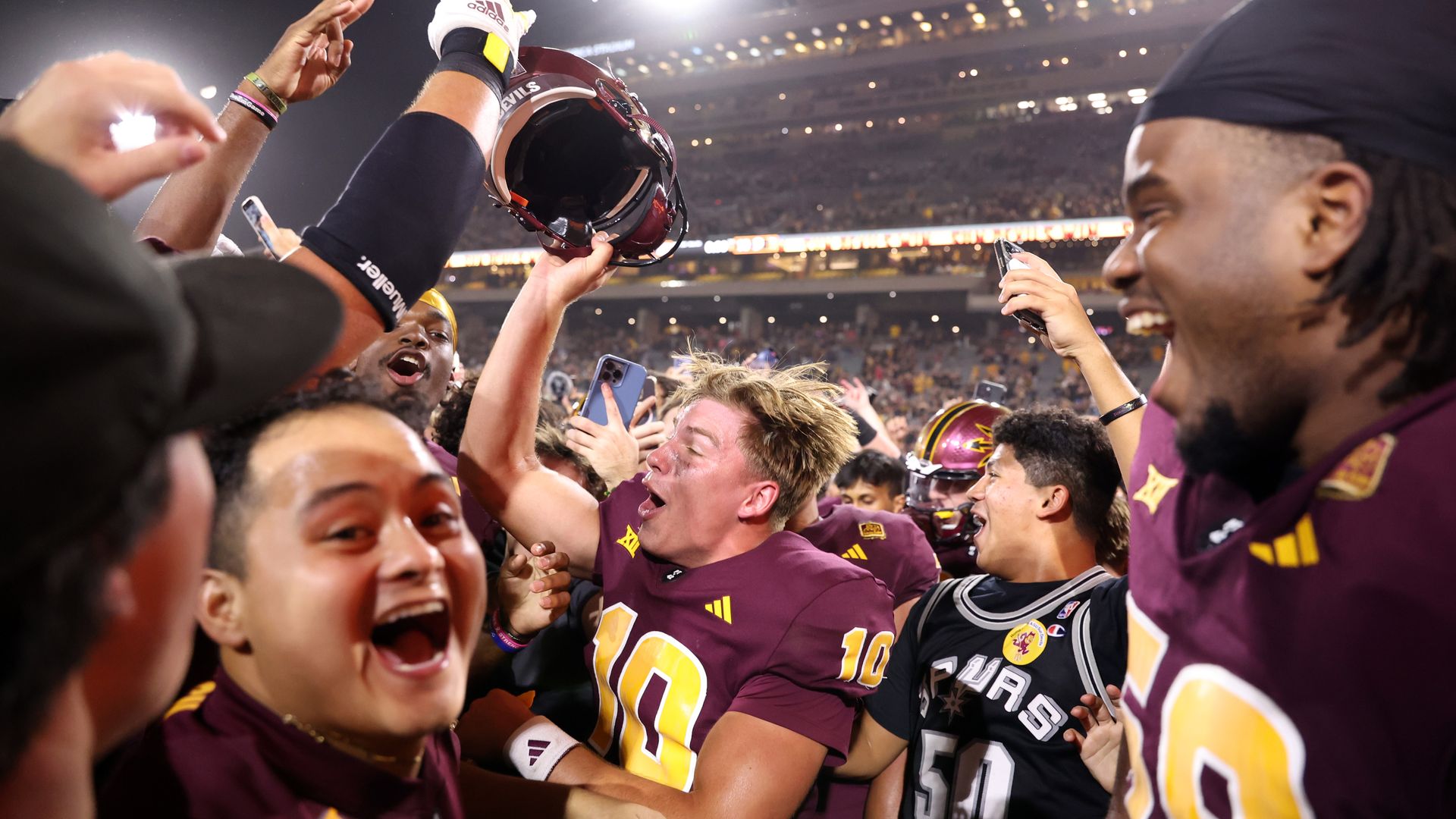 Football players celebrating with fans. 