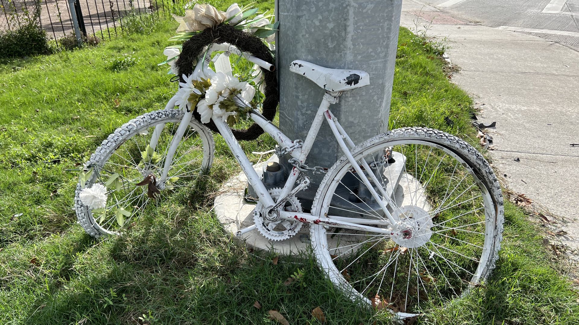 A ghost bike leans against a utility poll in Houston