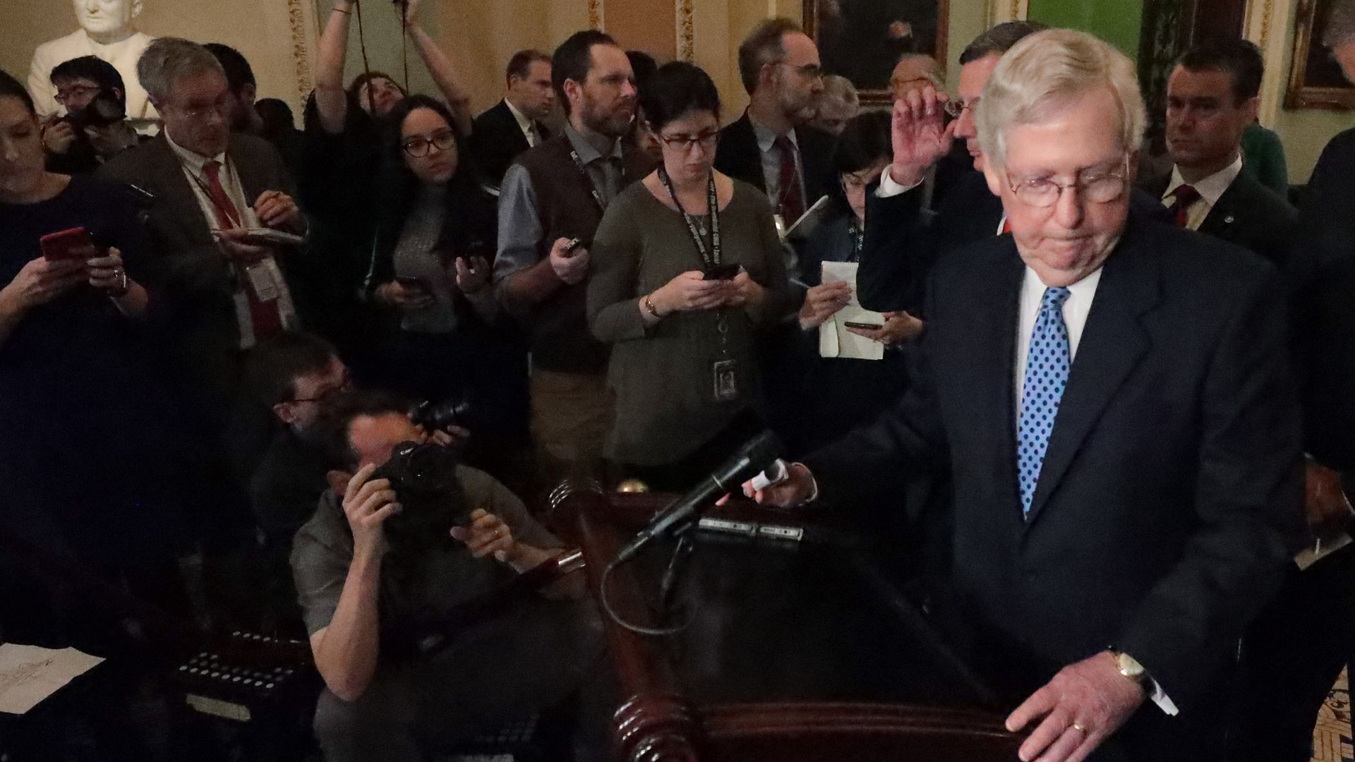 Mitch McConnell in a crowed of reporters