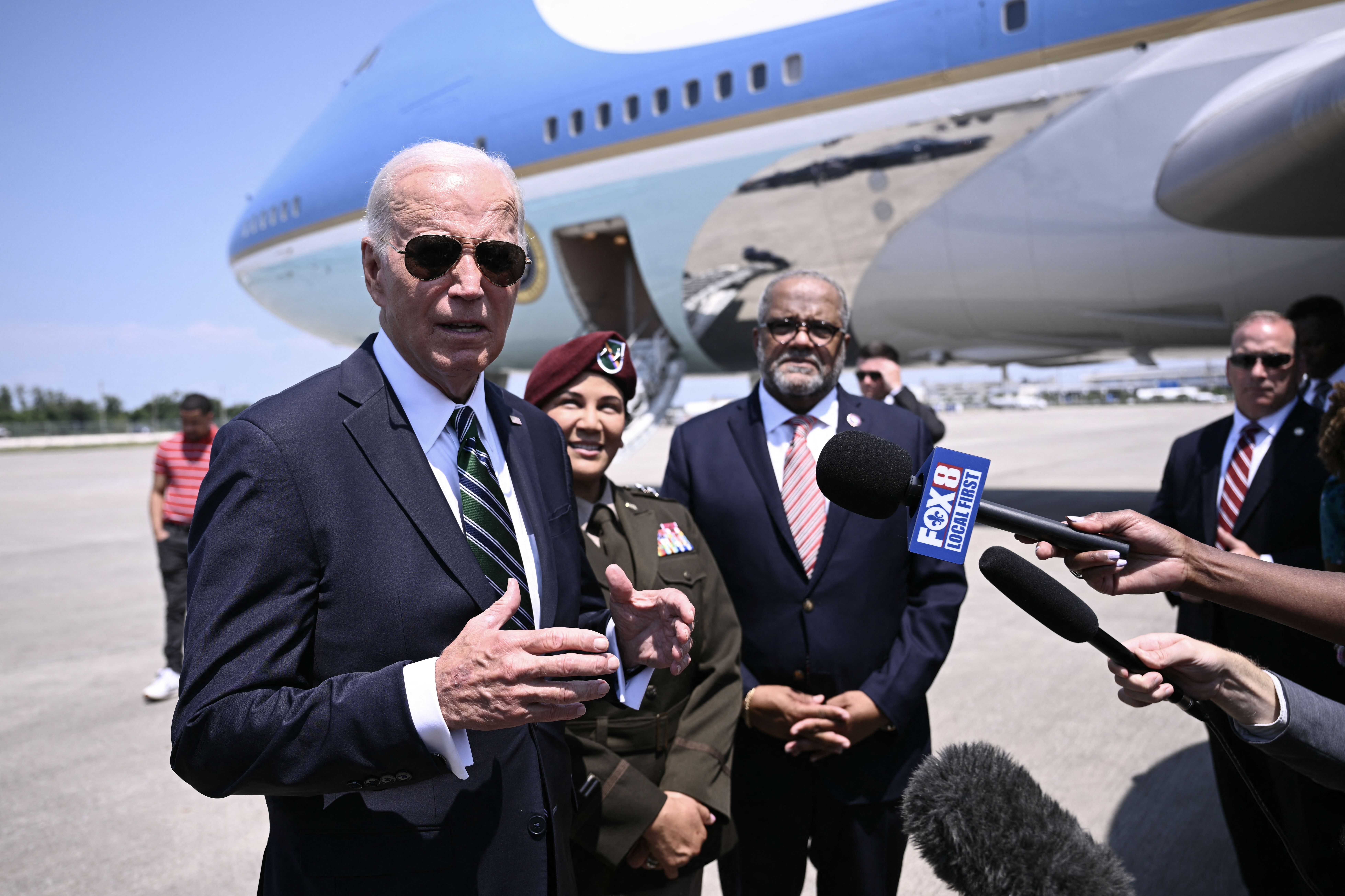 Photo shows President Biden talking with reporters in front of Air Force One in New Orleans.