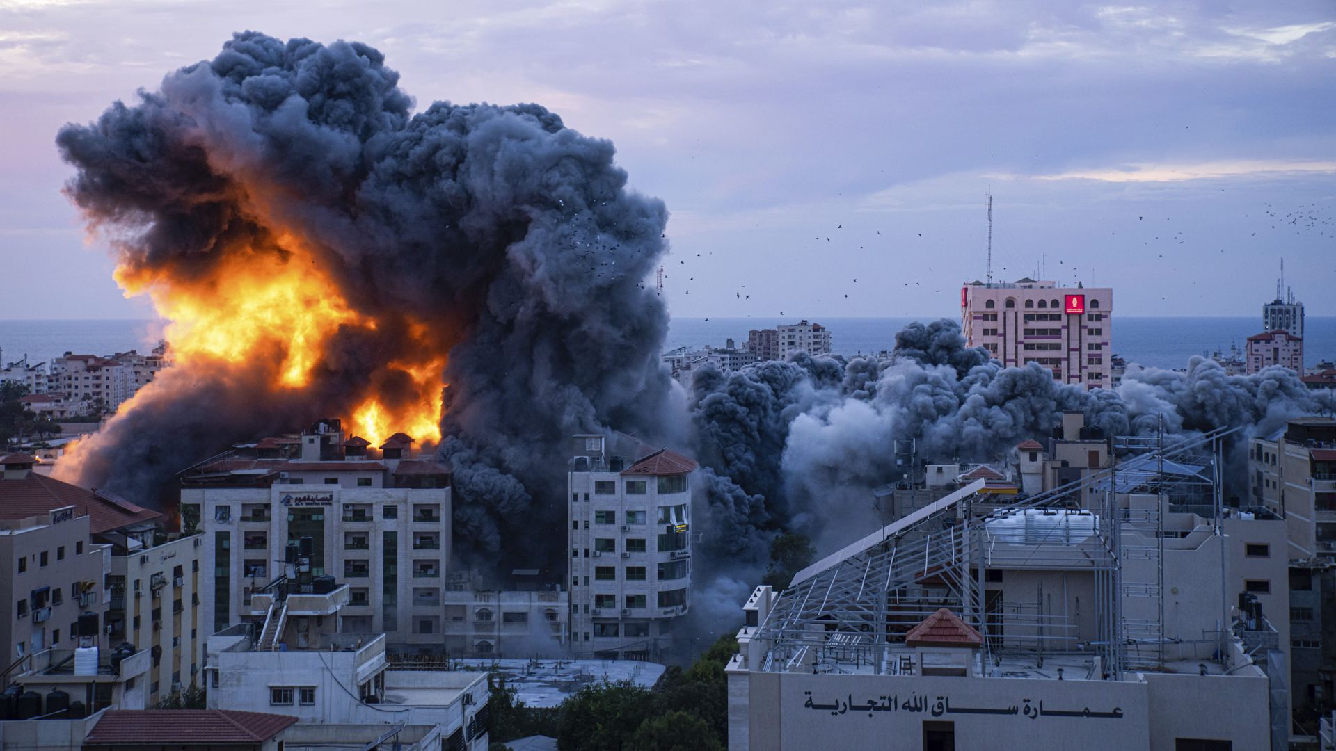Fire and smoke rise in Gaza City yesterday after an Israeli airstrike. Photo: Fatima Shbair/AP