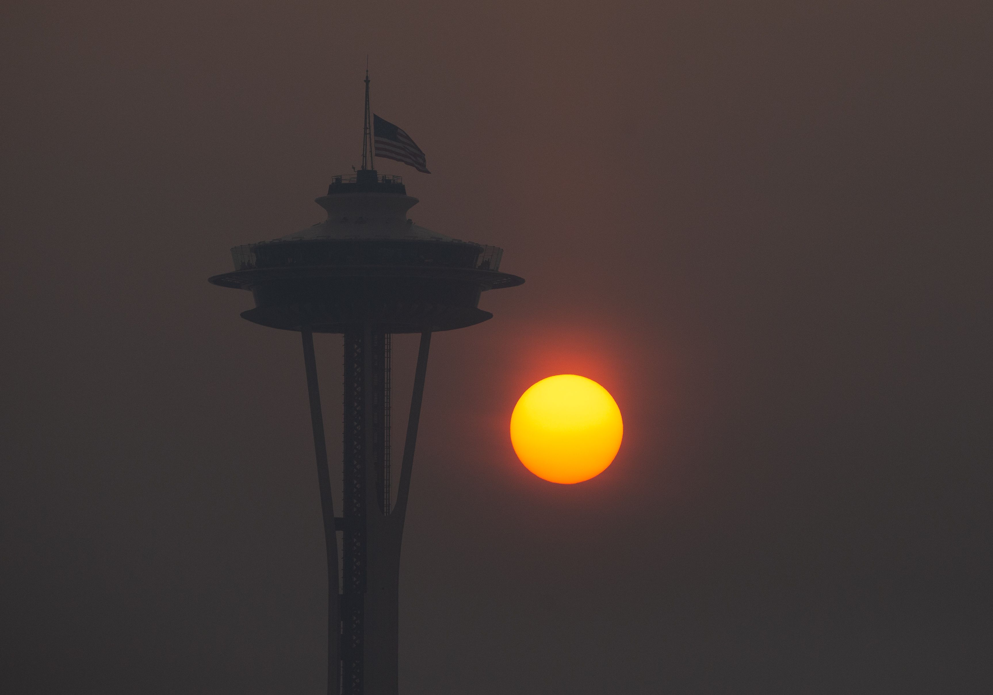 The sun sets through wildfire smoke in Seattle, Washington. 