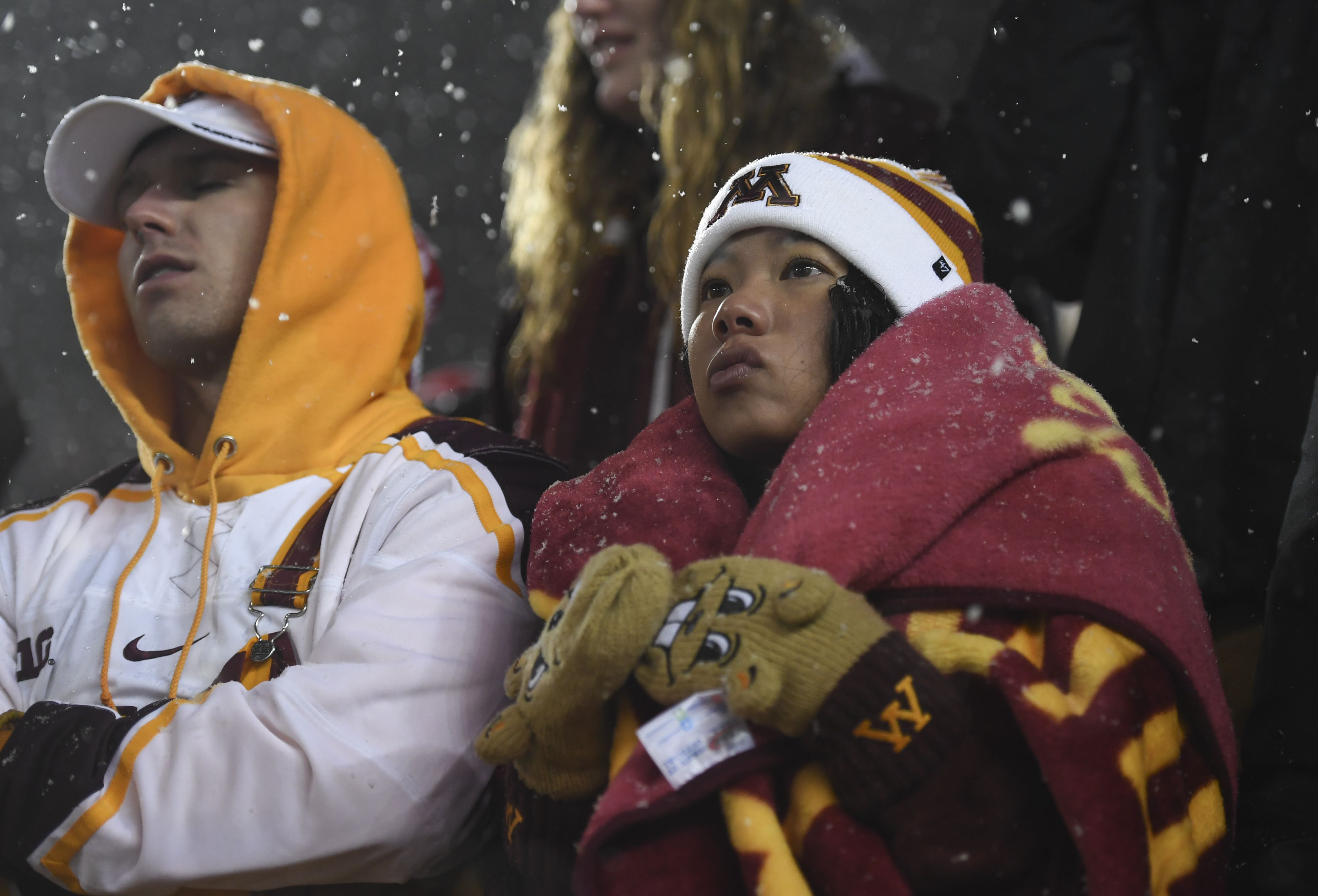 Two people in UMN sports outfits looking disappointed.