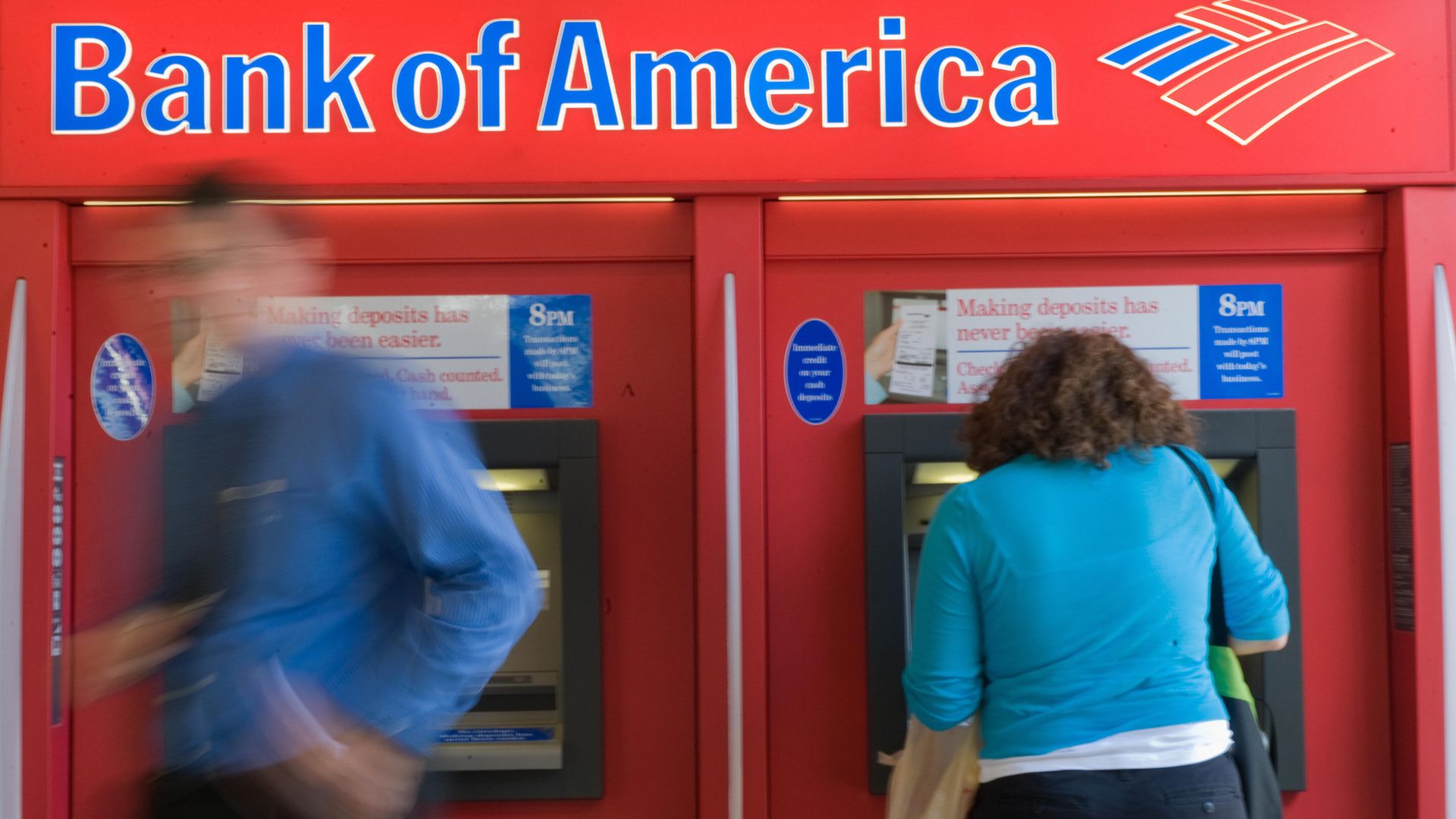 People use a Bank of America automatic teller machine.