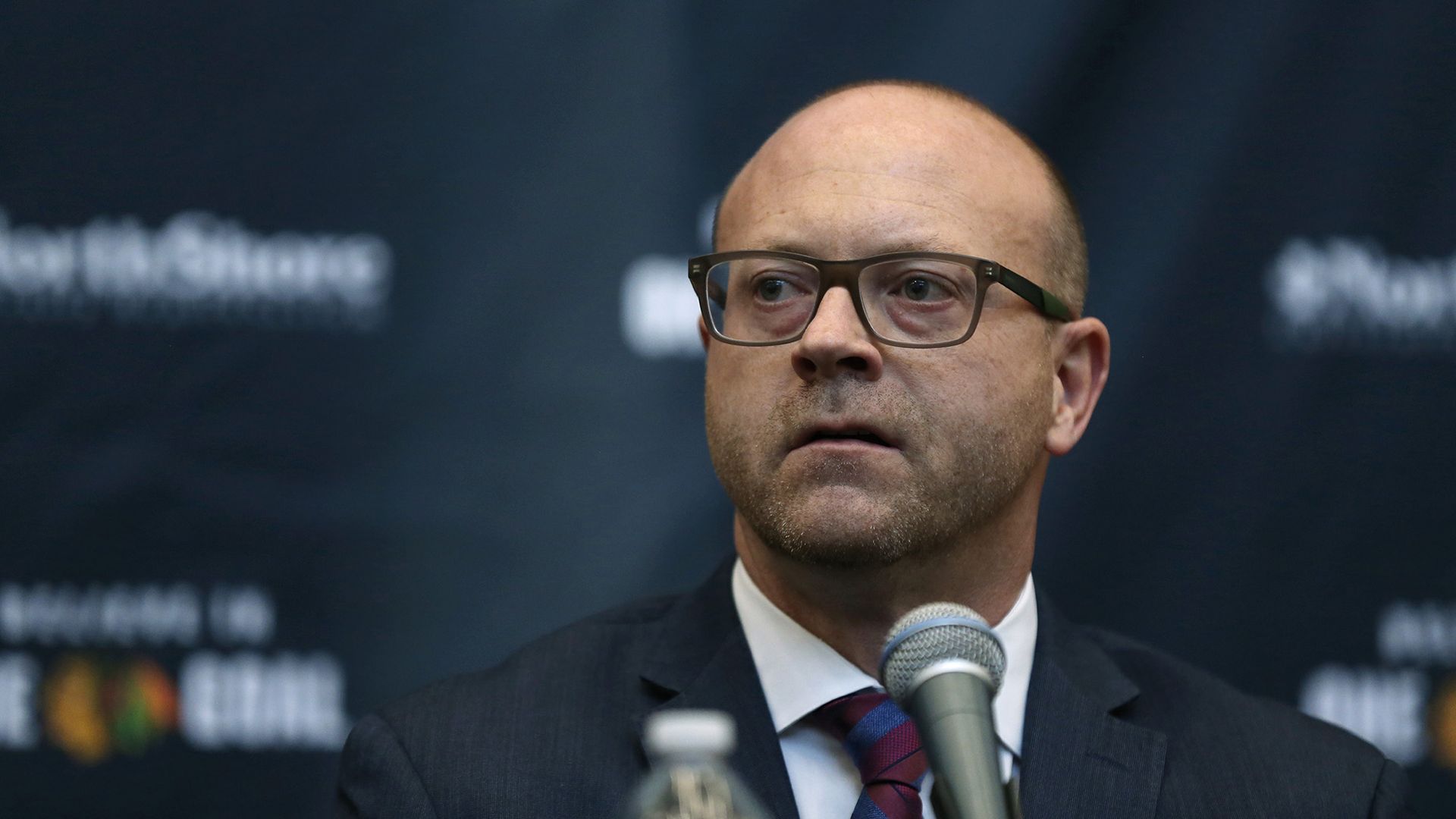 Stan Bowman talks into a mic at a press conference.