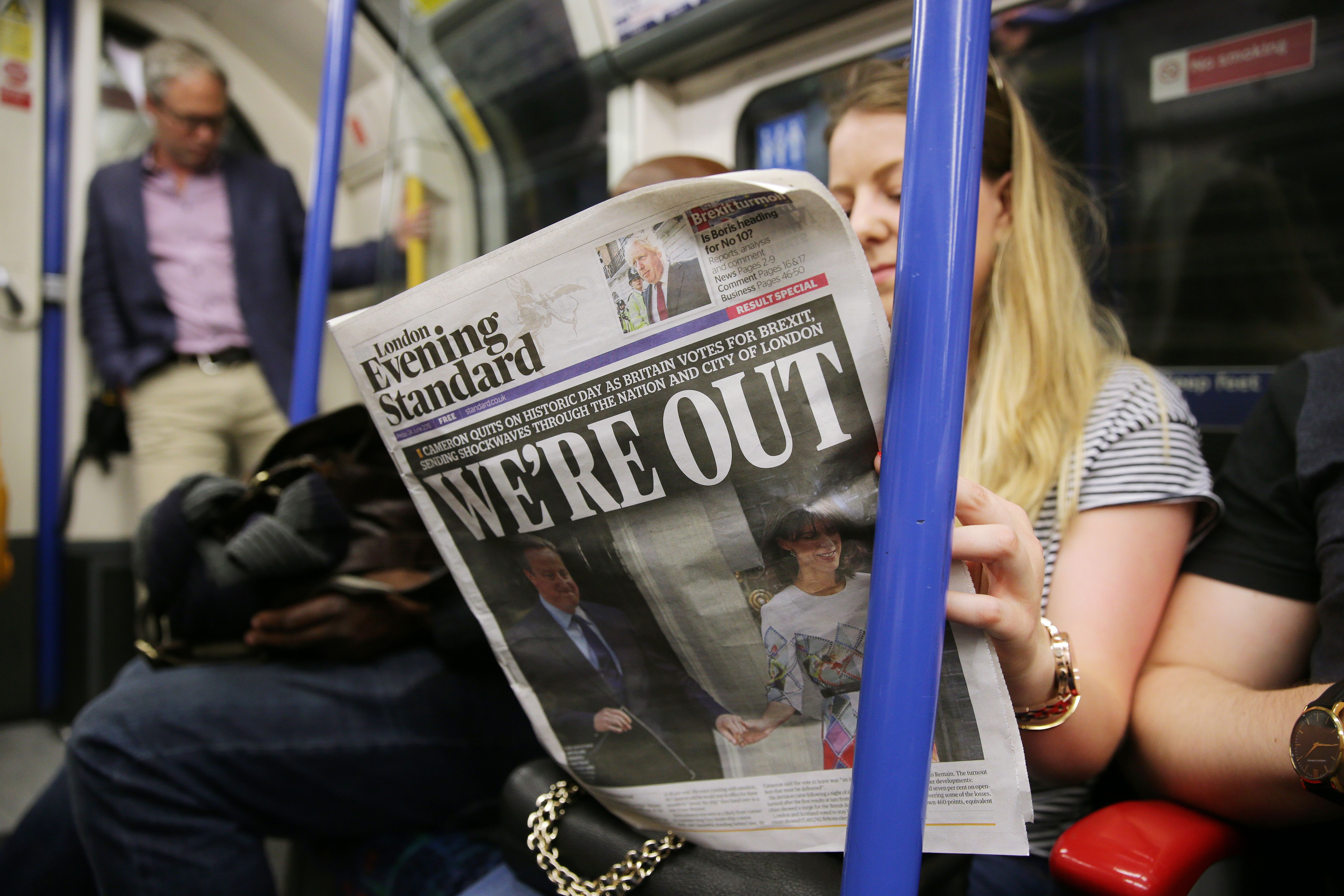 A woman reading a newspaper on the tube in London, England, 24 June 2016. 