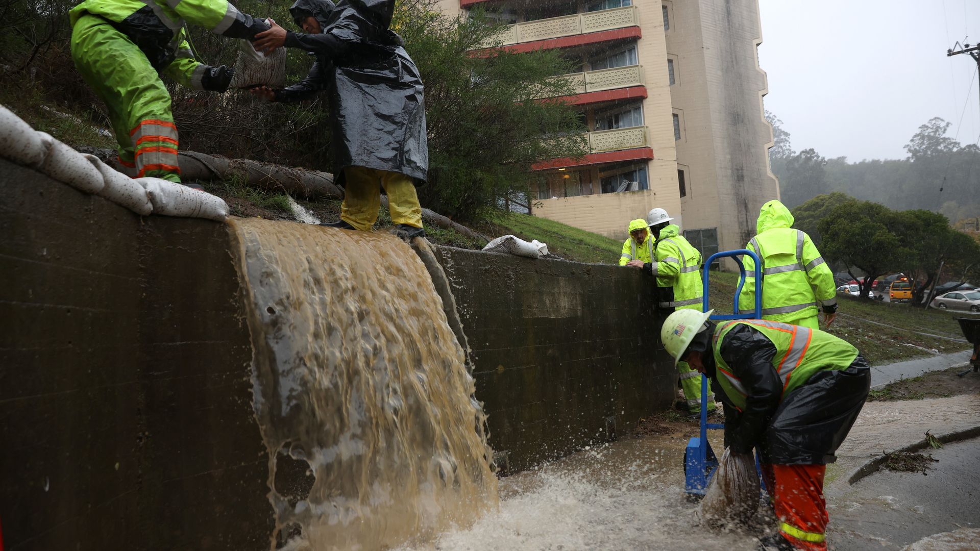  Workers try to divert water into drains as rain pours down on October 24, 2021 in Marin City, California. 