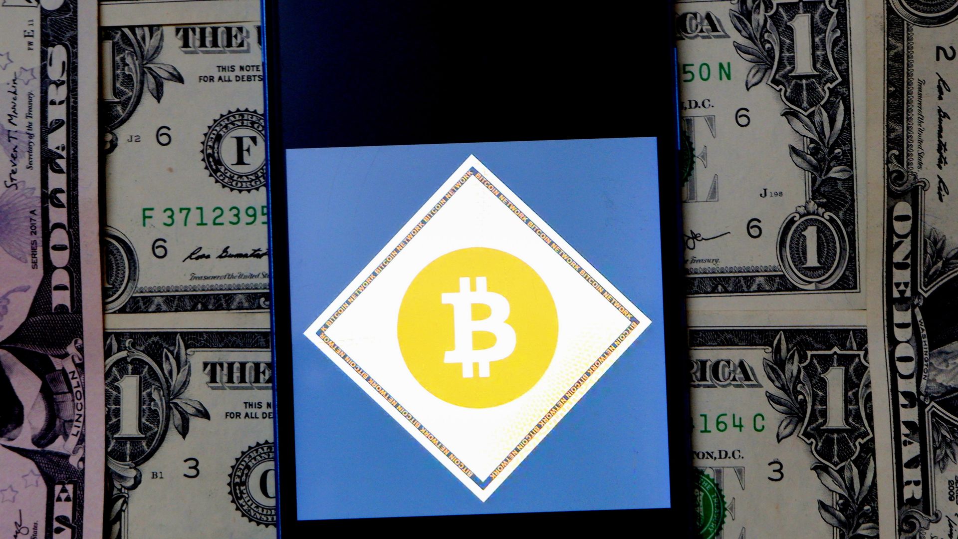 Illustrative image of two commemorative bitcoins seen in front of the national flag of the United States displayed on a computer screen. Photo by Artur Widak/NurPhoto via Getty Images)