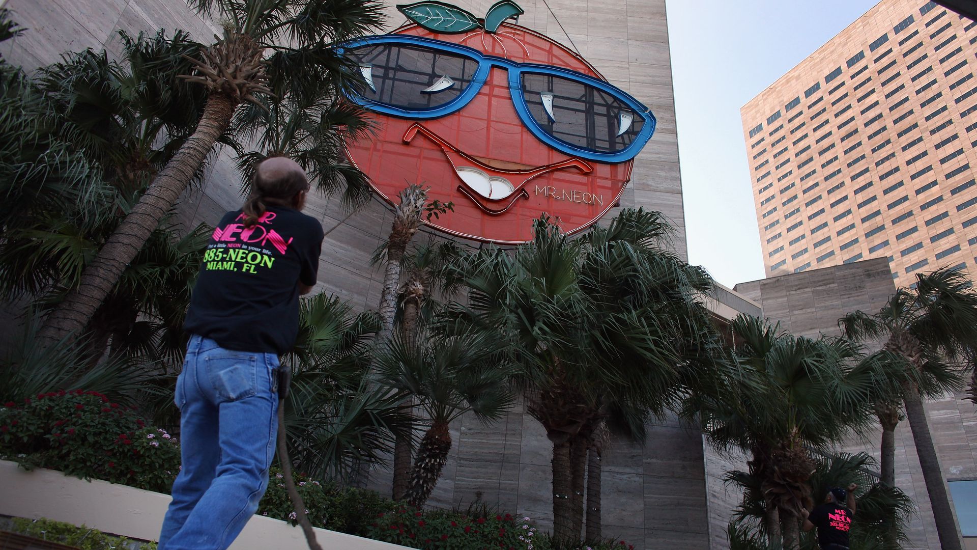 MIAMI, FL - DECEMBER 28: Bill Flaherty from Mr. Neon inc. helps place the Big Orange New Years time ball onto the side of the Hotel InterContinental on December 28, 2011 in Miami, Florida. The 35-foot ball rises 400 feet to the top of the building and is lowered at midnight on the 31st to mark the b