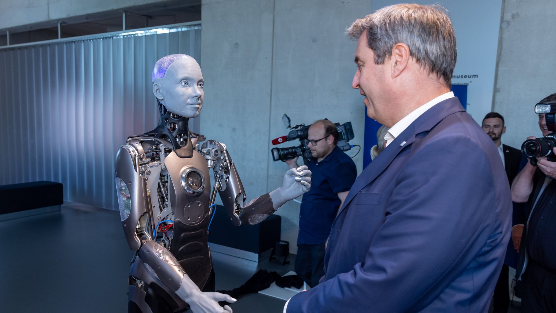 A humanoid robot greets a Bavarian official.