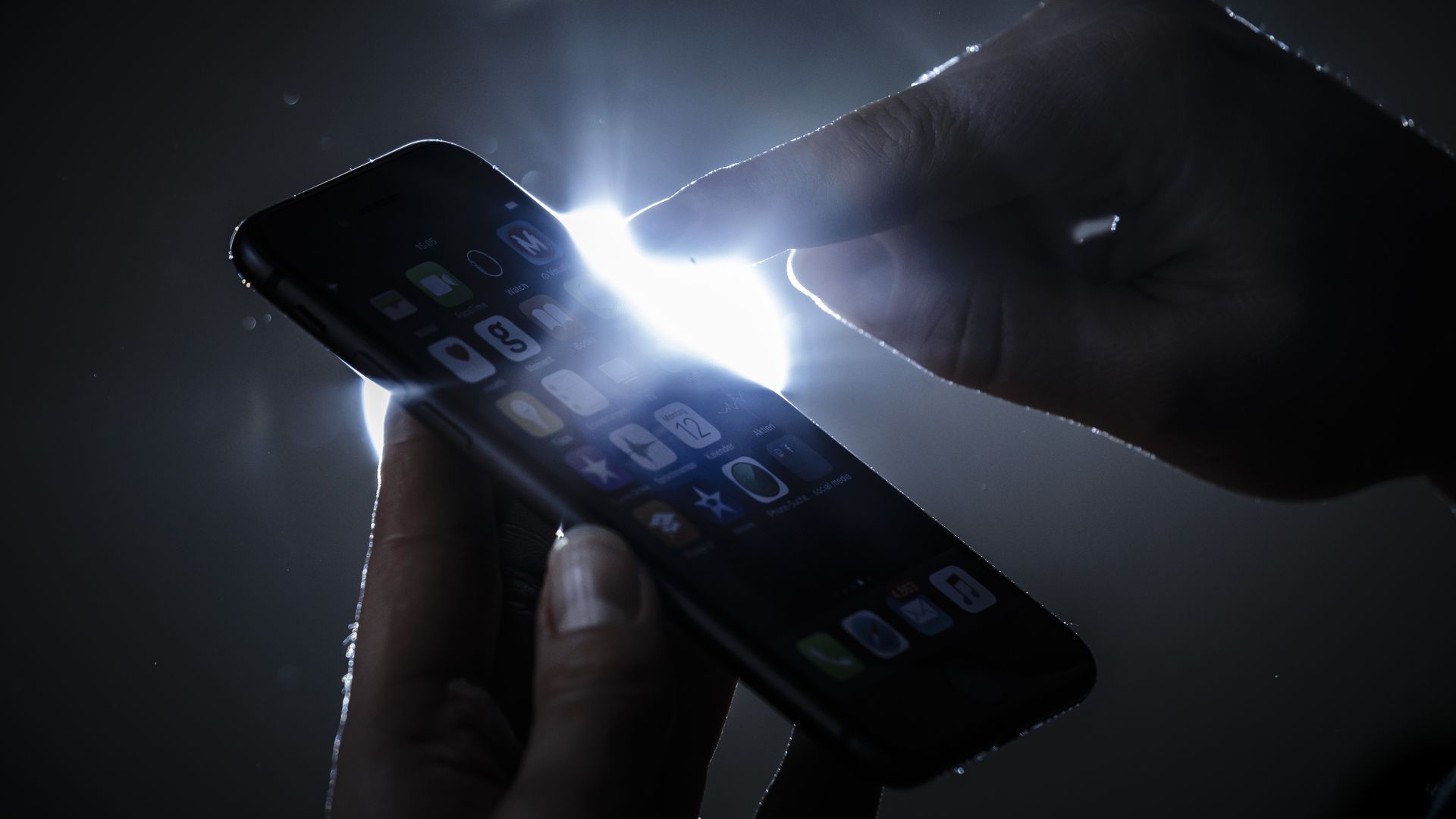 A hand is poised over a phone touchscreen