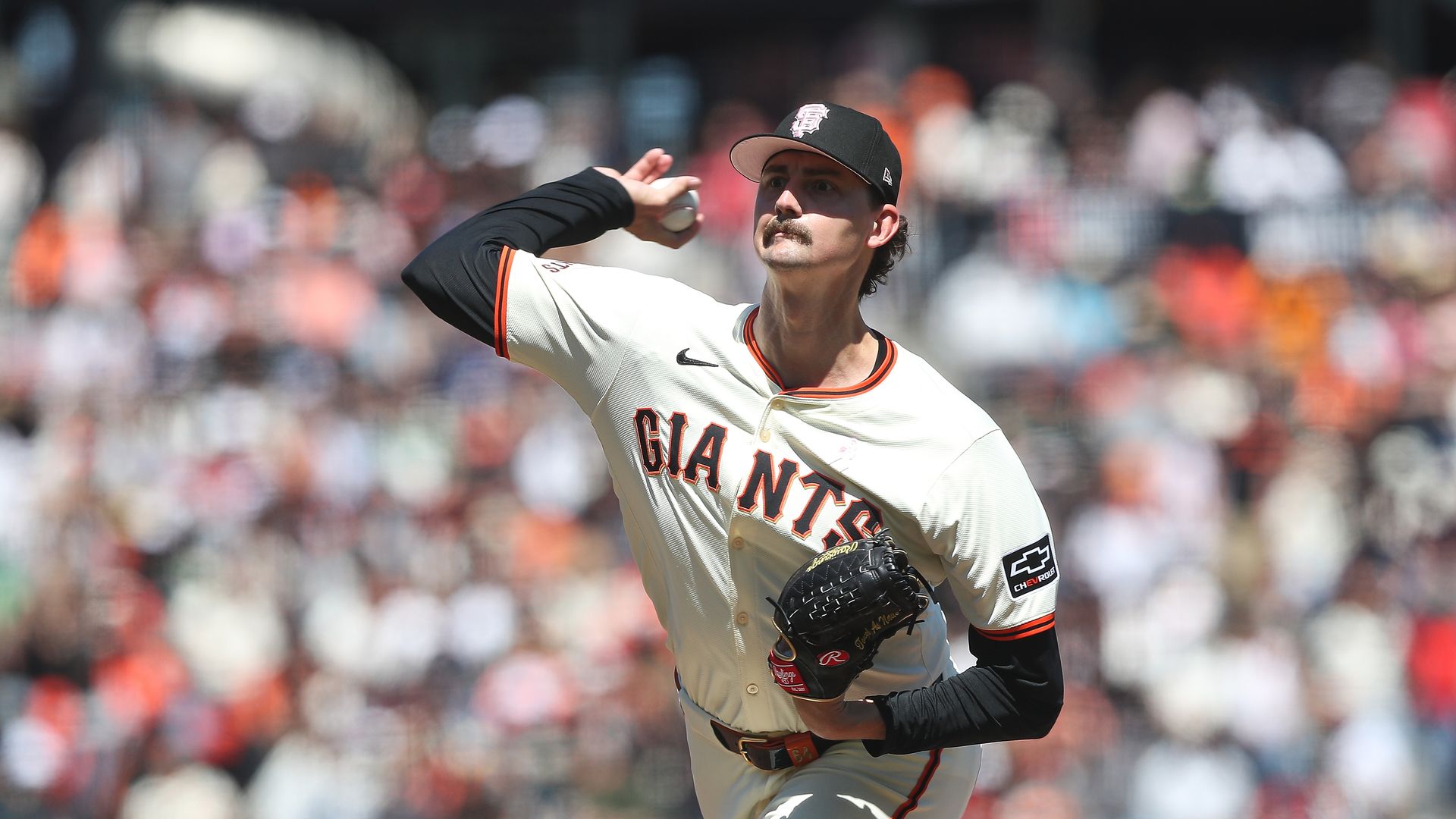 person throwing a ball wearing a giants uniform