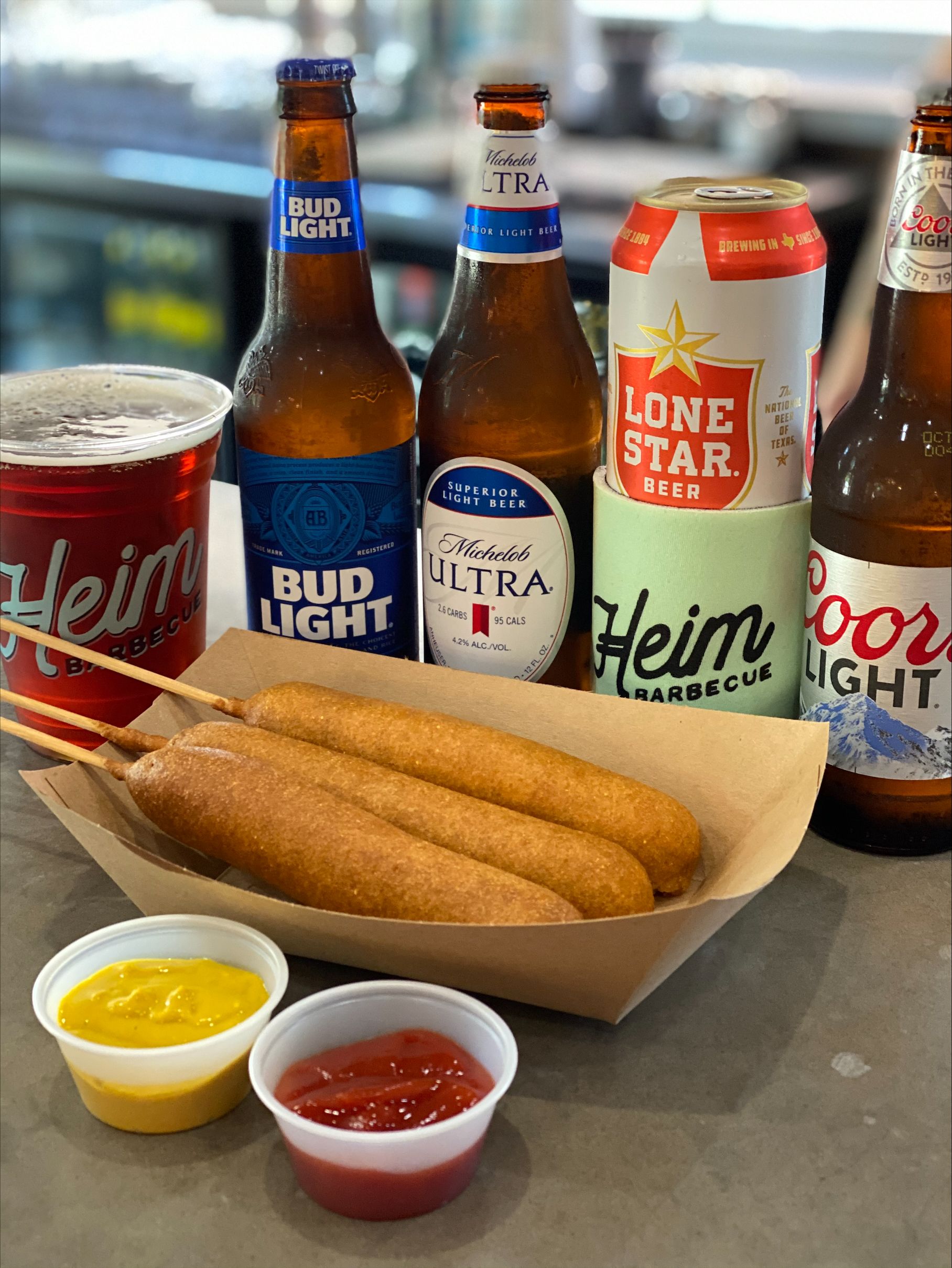 corn dogs in a basket in front of beers