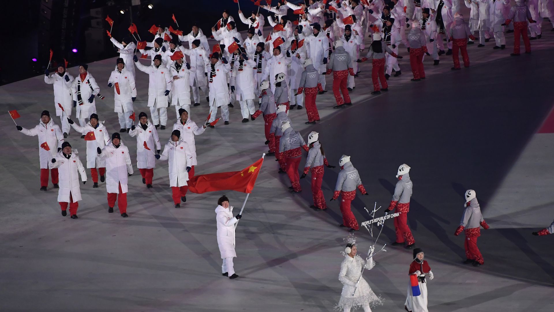 The Chinese delegation, led flagbearer Zhou Yang, parades in the opening ceremony of the 2018 Winter Olympic Games.