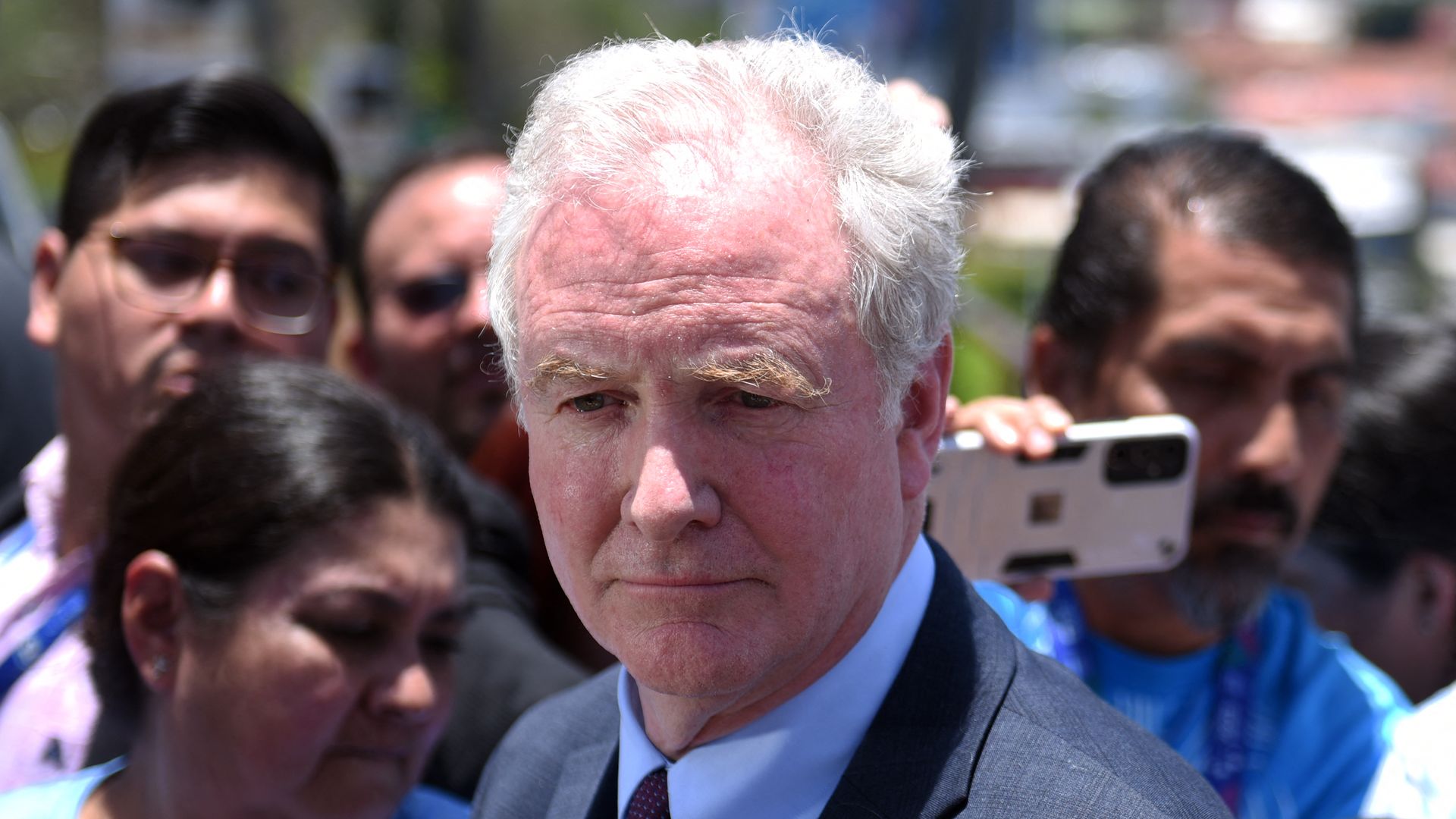 People gather around Sen. Chris Van Hollen during a press conference in El Salvador.