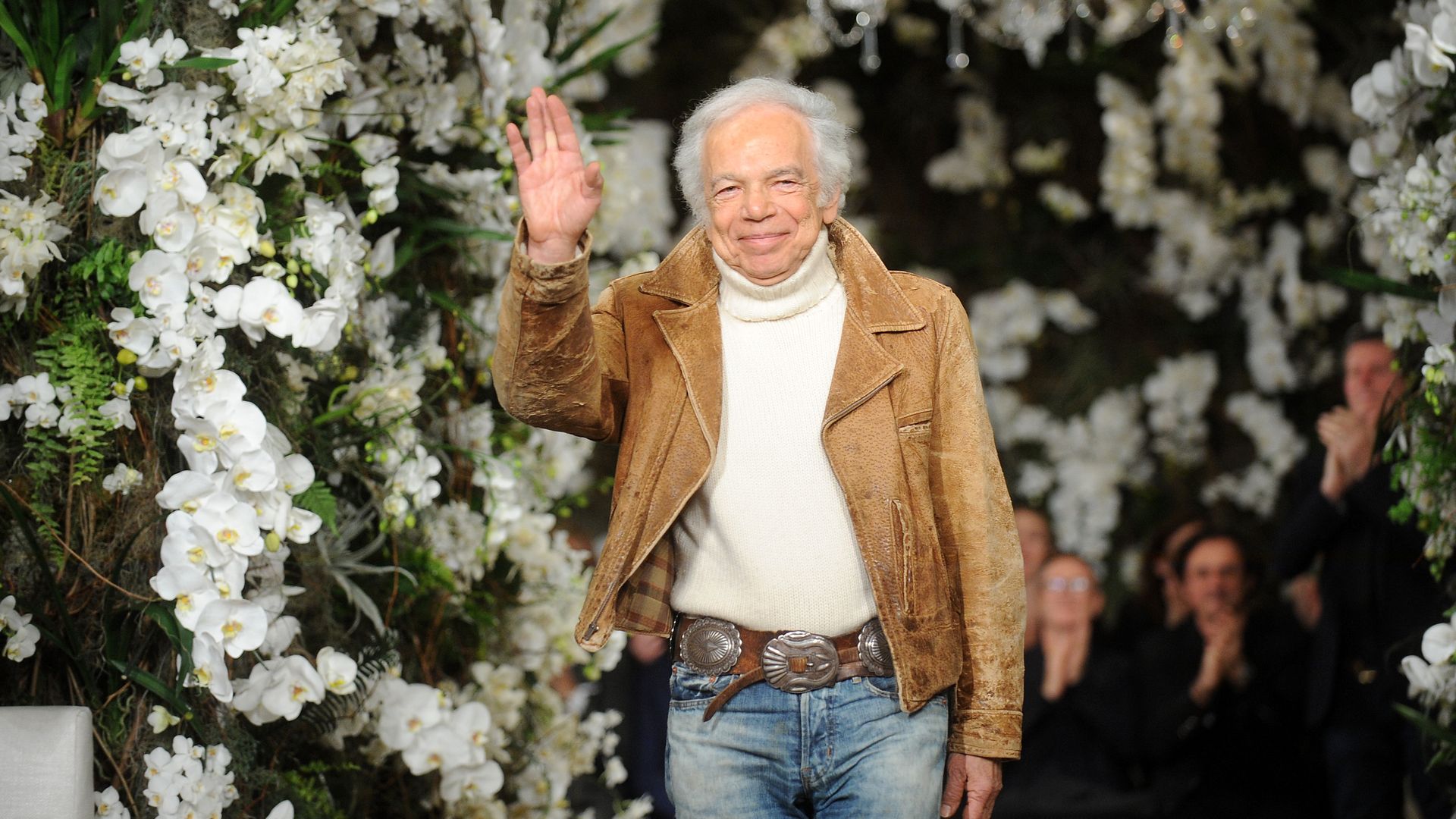 Ralph Lauren waves at audience at end of fashion show. 