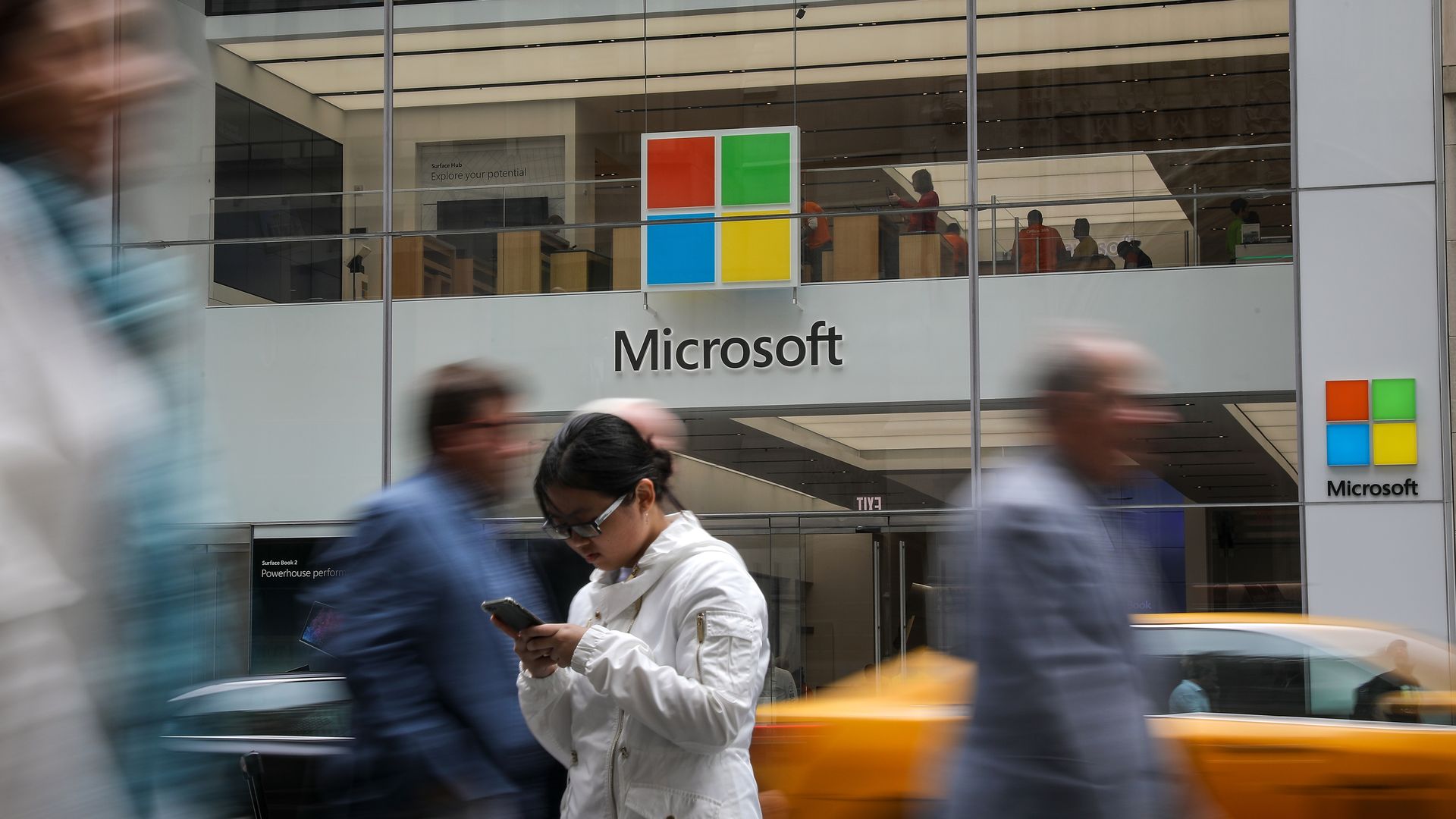 People walking past a Microsoft store in New York City.