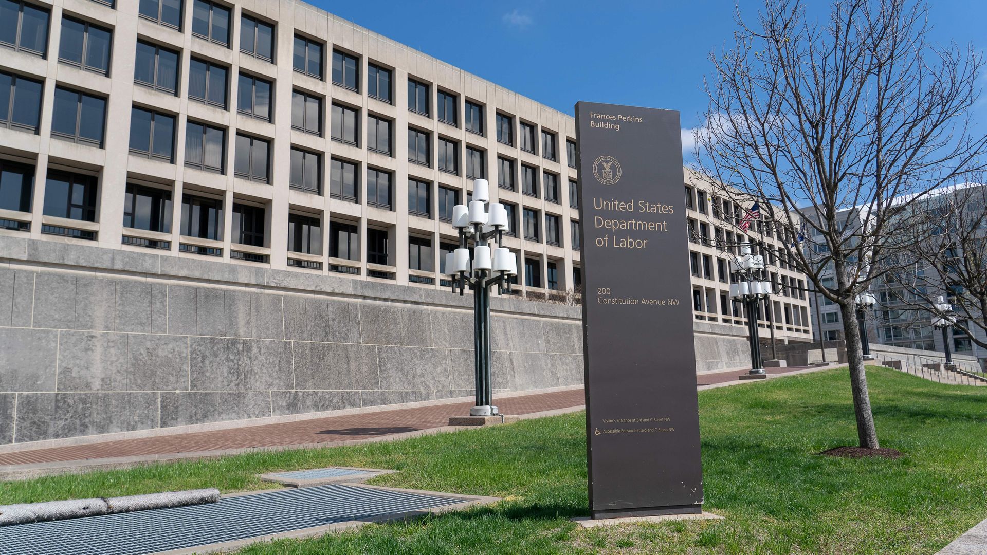 Photo of the Department of Labor building on a sunny day with a sign in front of it that says its name