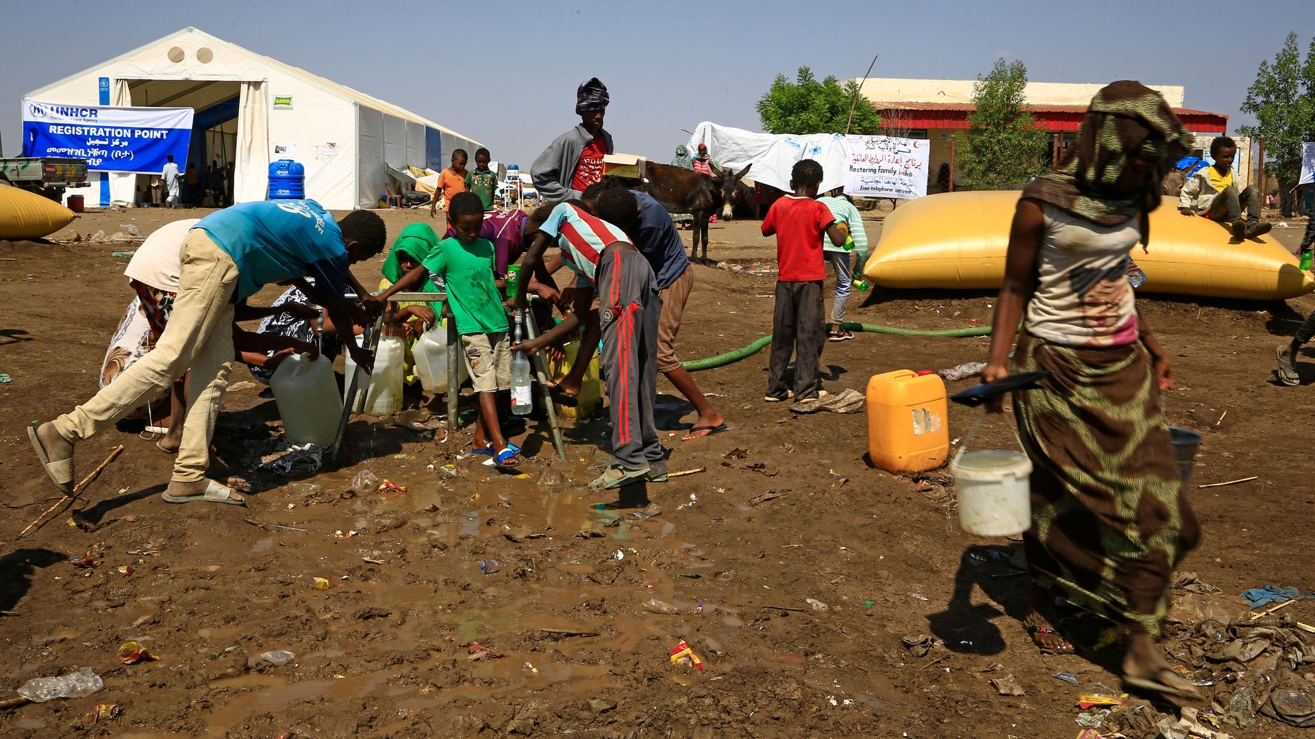 Picture of Ethiopian refugees who have fled the Tigray conflict filling up water bottles