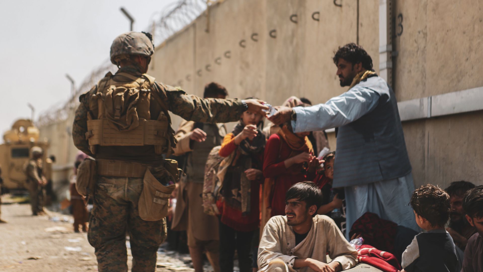 A U.S. Marine giving out water to evacuees at Hamid Karzai International Airport in Kabul, Afghanistan, in August 2021.