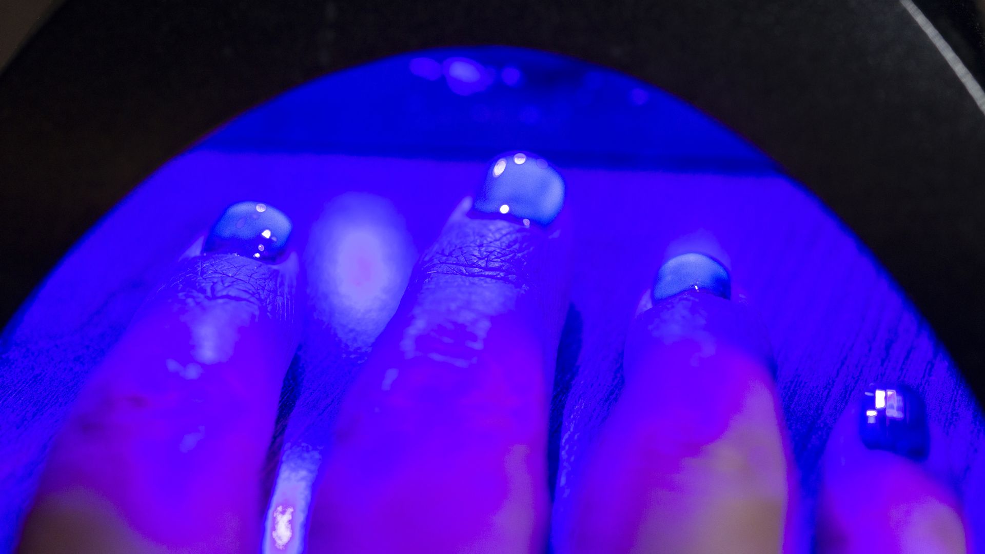 Manicured hand is cured under UV light