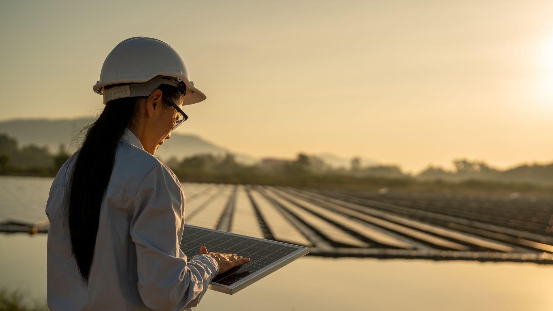 Woman standing in a field of solar panels.