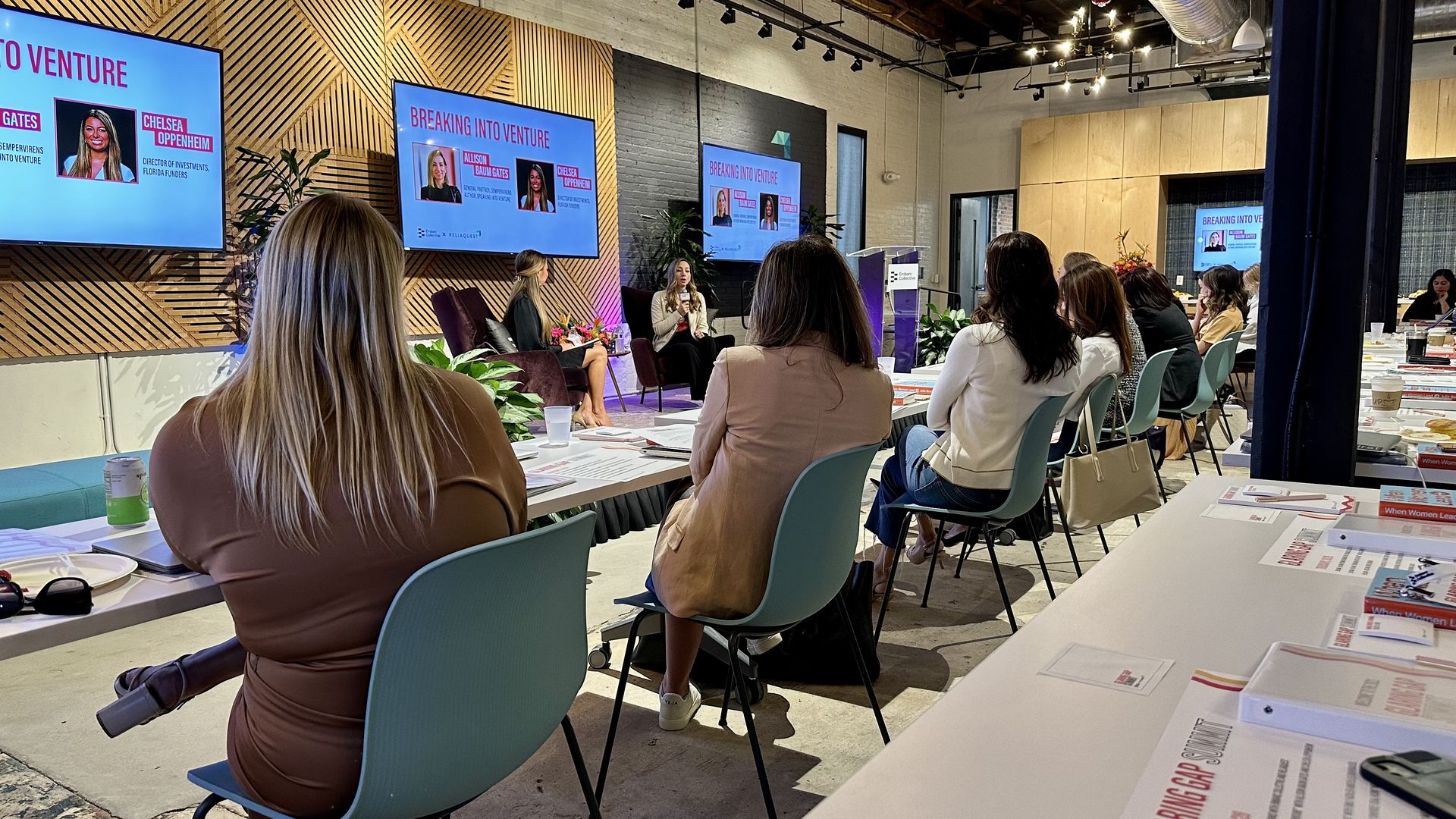Women watch Allison Baum Gates speak onstage