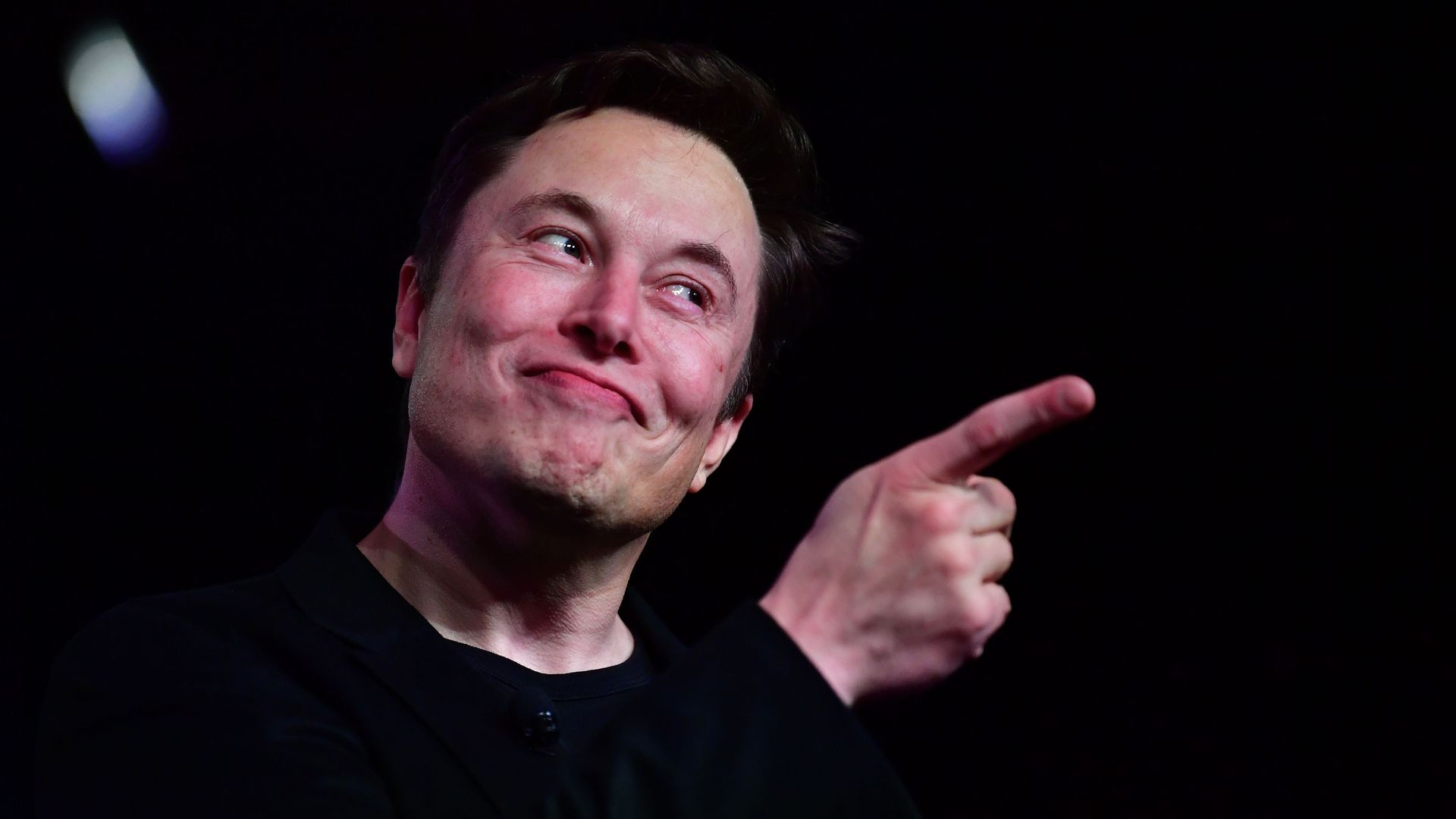 Photo of Elon Musk smiling and pointing his finger