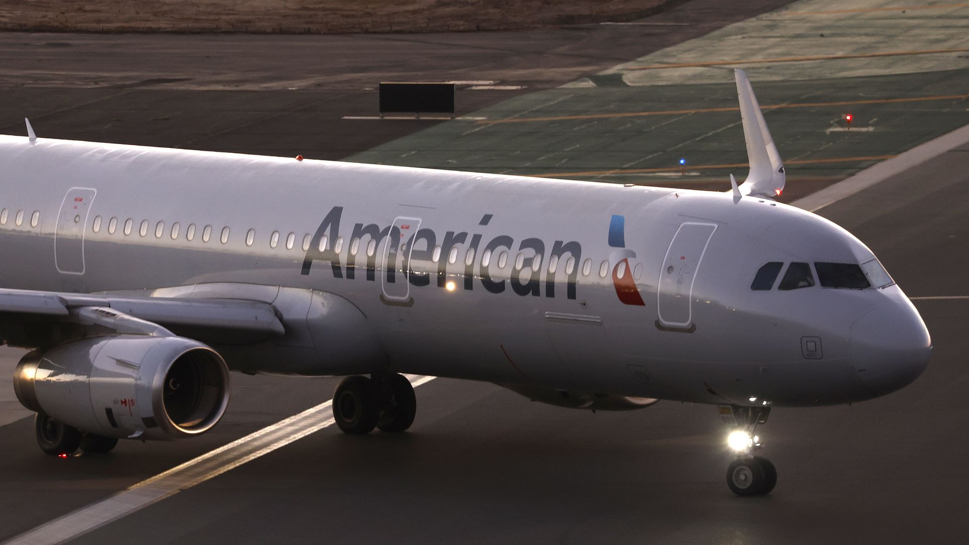 An American Airlines Airbus A321-231 airplane taxis to depart at sunset.