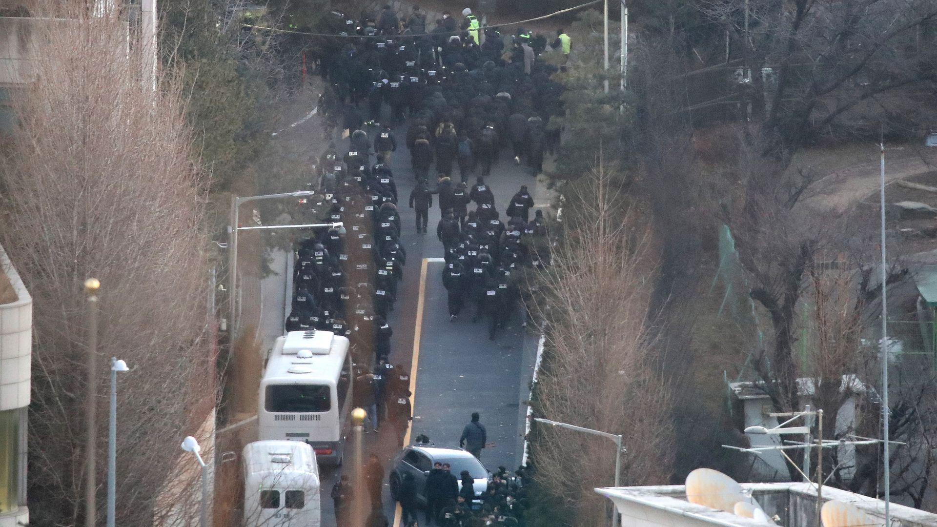 Members of the Corruption Investigation Office for High-ranking Officials and police officers make their way towards the presidential residence in Seoul to serve a warrant to detain Yoon on Jan. 15. 