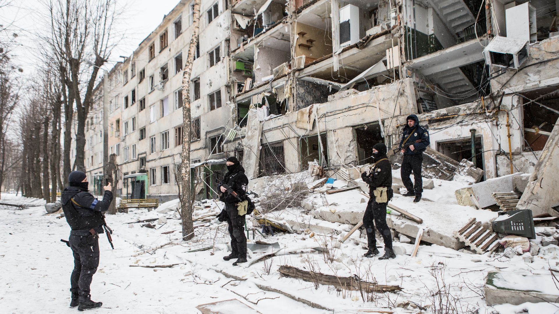Policemen take photos of themselves in front of the bombed building in Kharkiv, Ukraine on March 10.